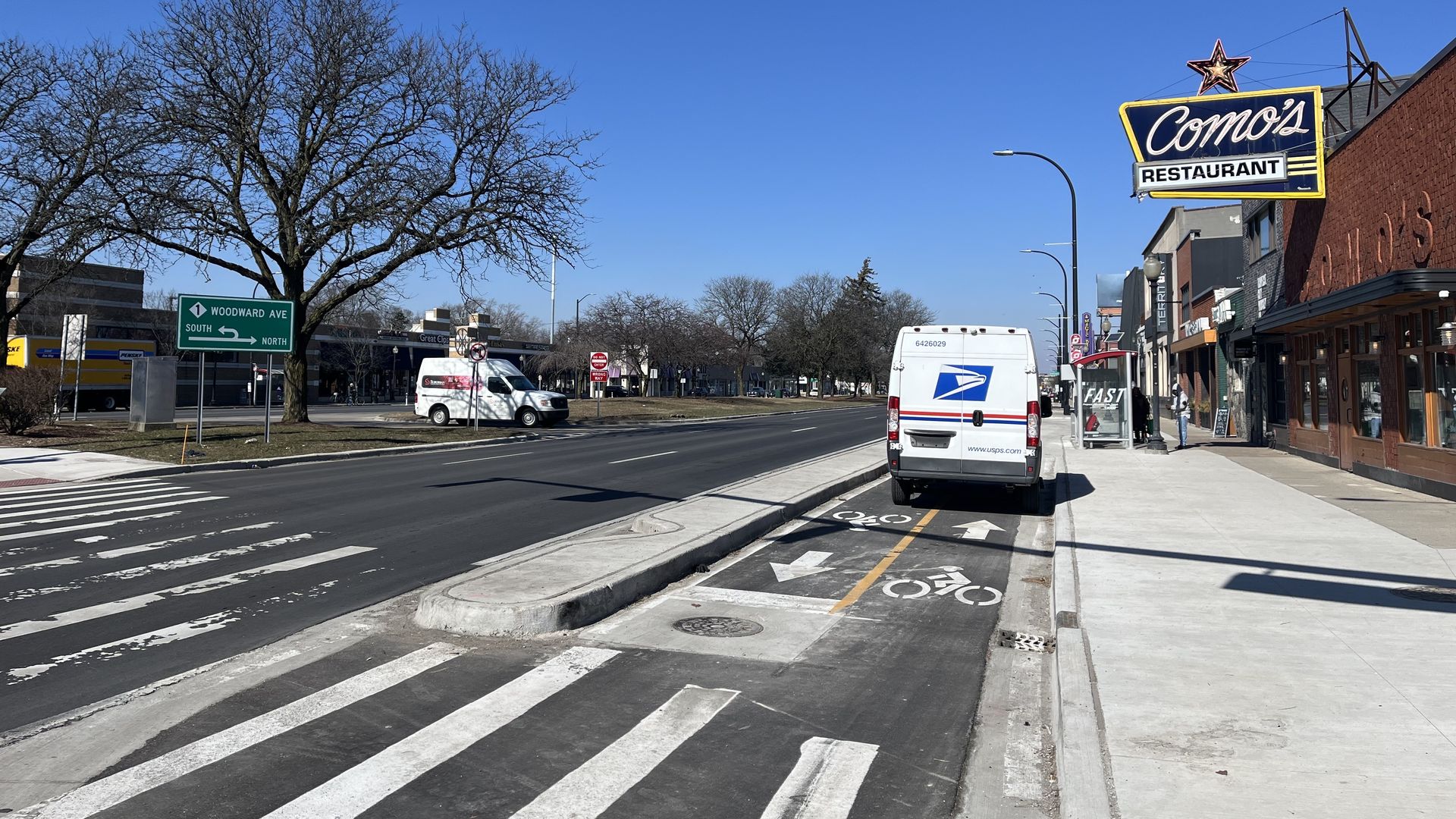 A postal truck is parked on bike lanes in Ferndale in front of Como's.