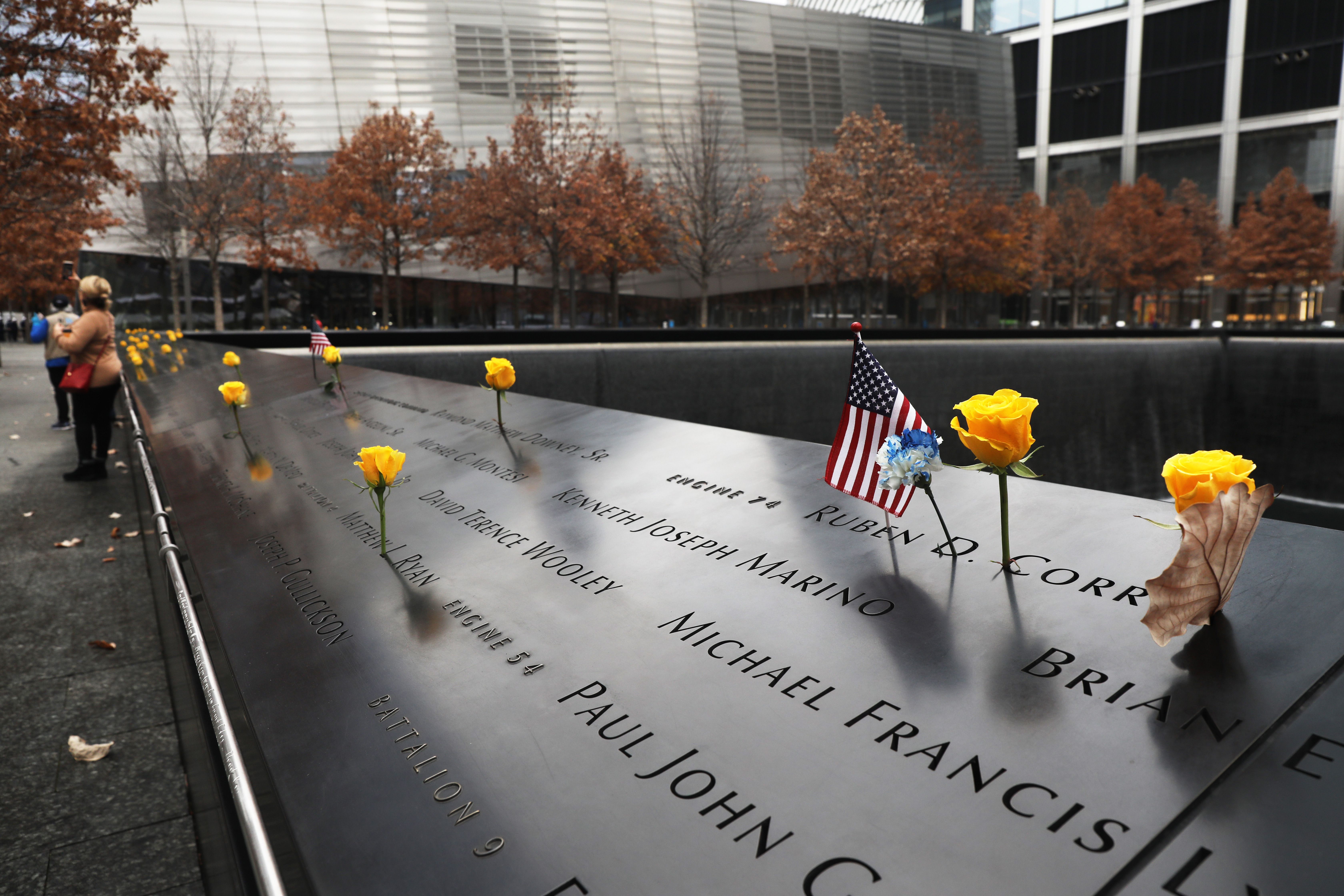 Flowers and flags are placed on the names of veterans killed in the attacks on September 11 at the memorial at Ground Zero on Veterans Day on November 11, 2020 in New York City. 