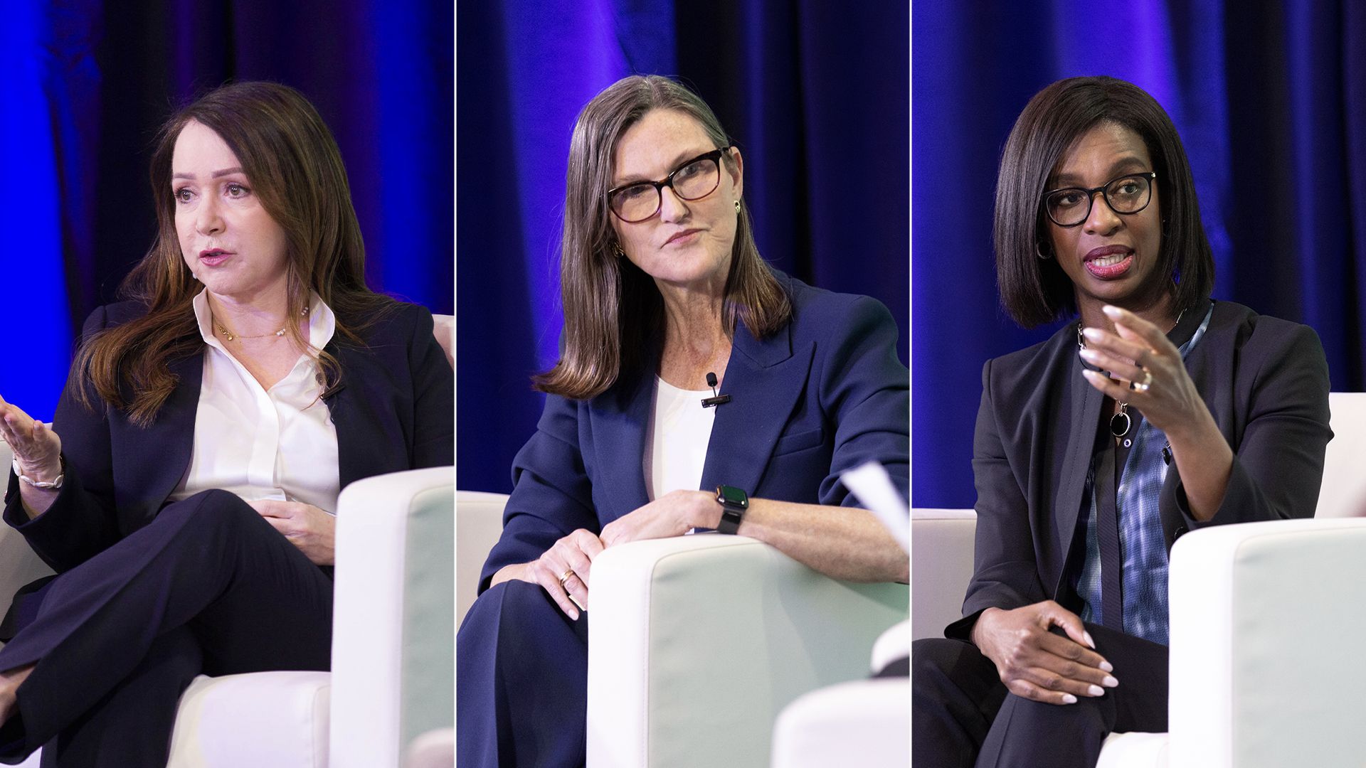 three women in power suits on stage sitting on white couch