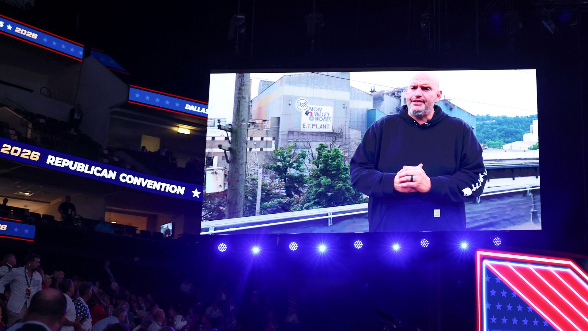 Sen. John Fetterman appears on a big screen before a darkened GOP convention hall.