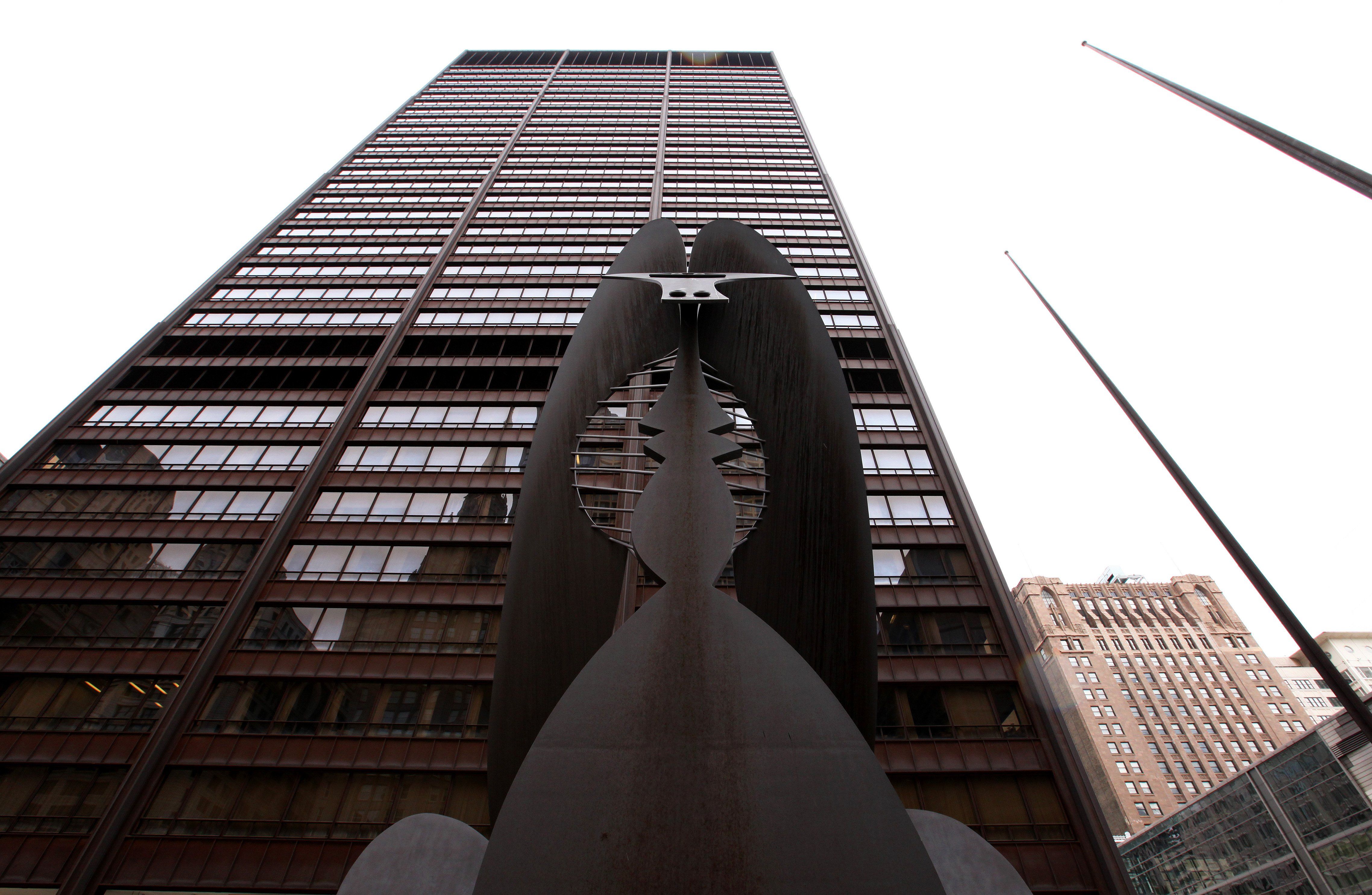 Photo of a tall building with a sculpture in front of it. 