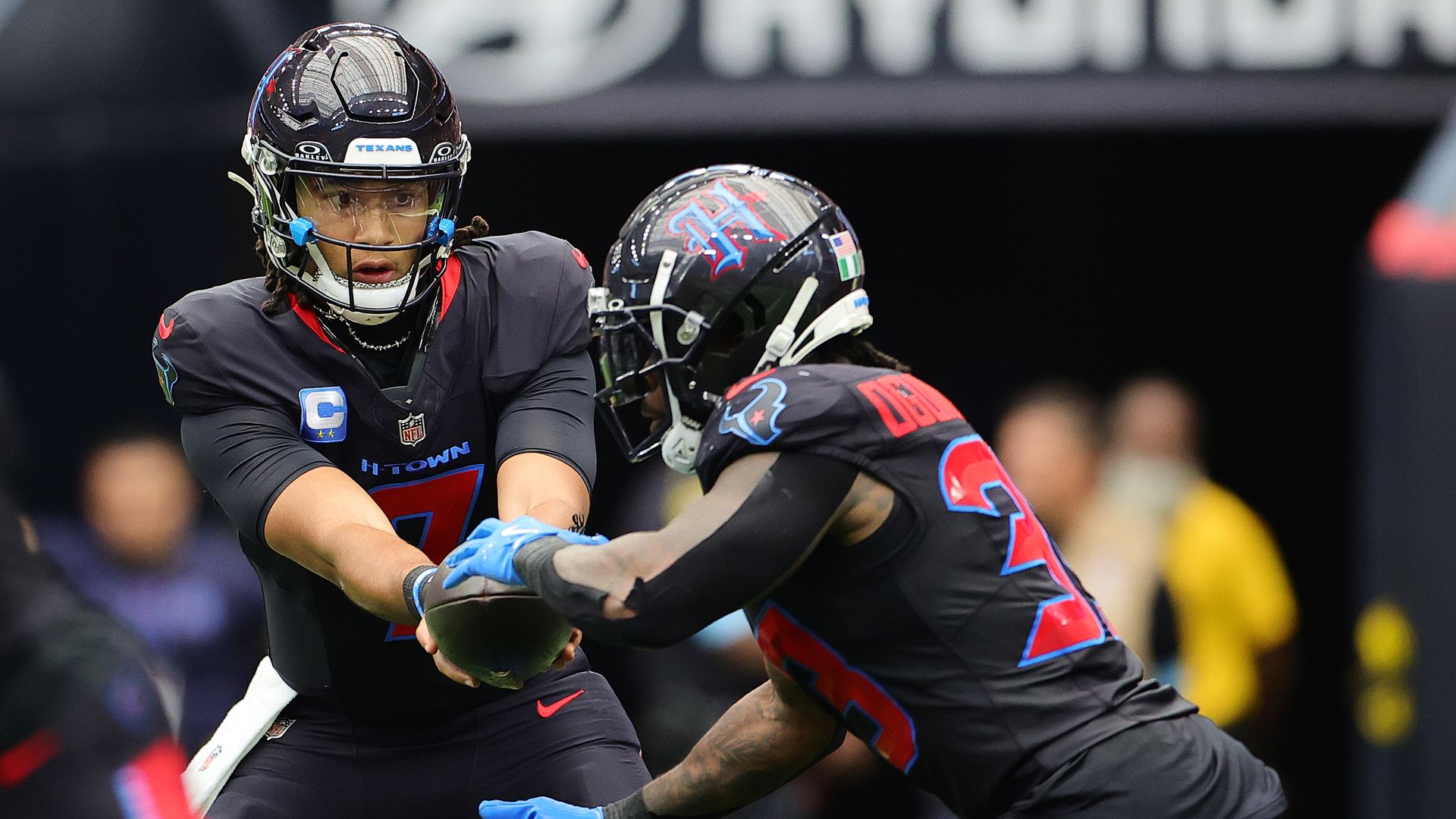 Texans quarterback C.J. Stroud hands off a football during a play