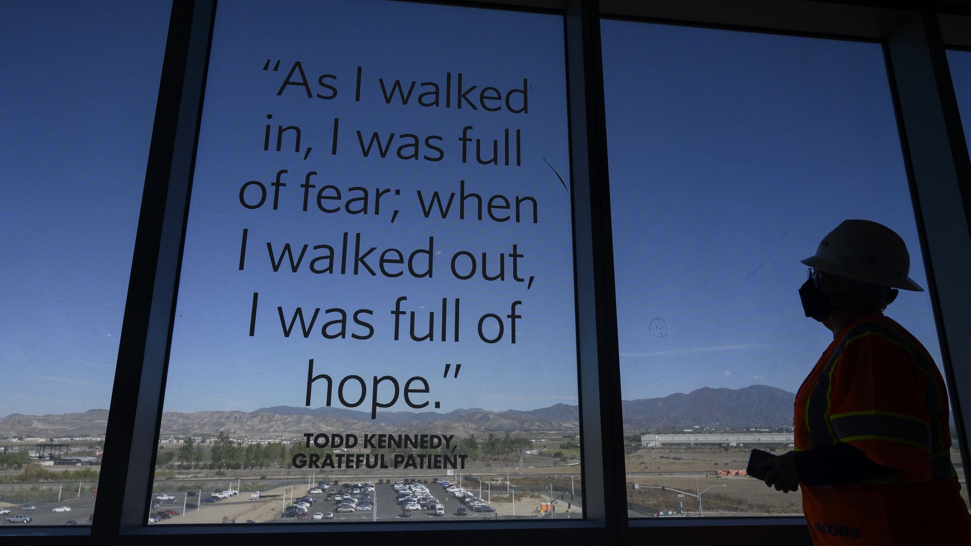 A construction worker stands by a window of a new cancer outpatient center.