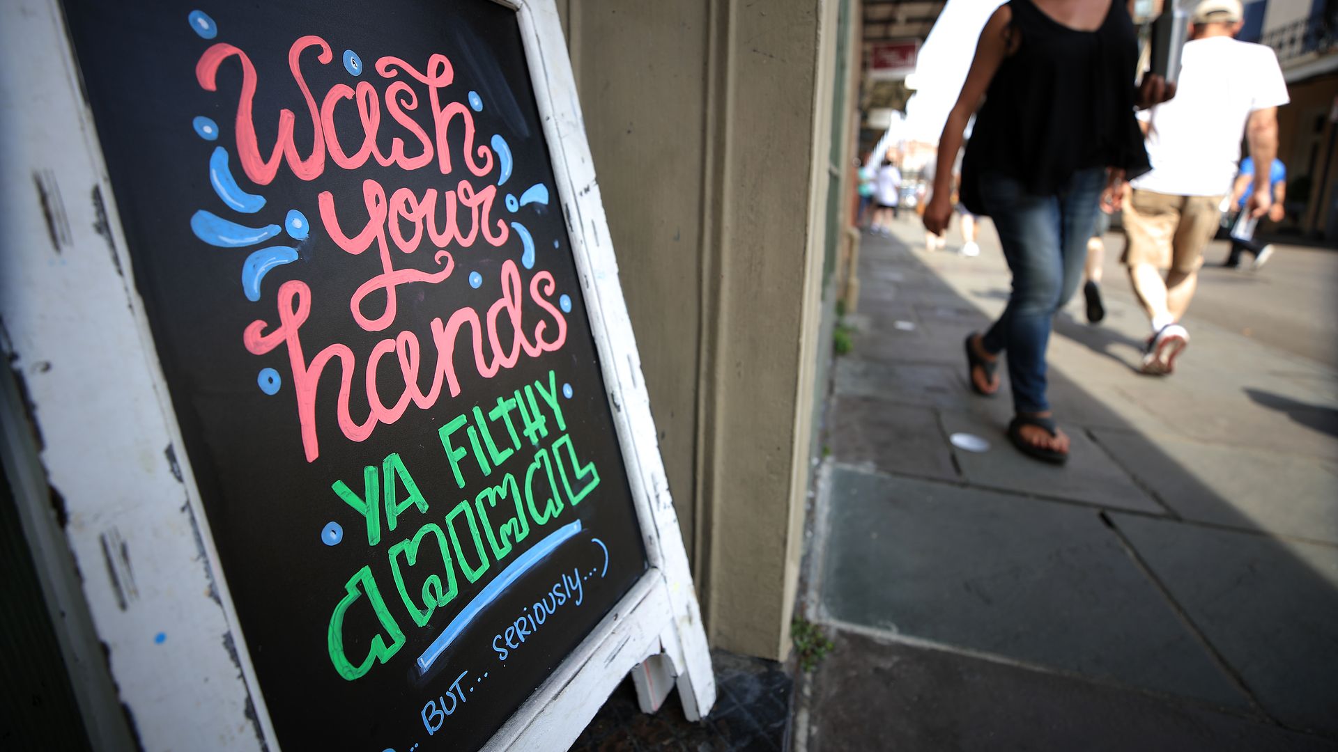 A sandwich board sign says "Wash your hands, ya filthy animal. But seriously."