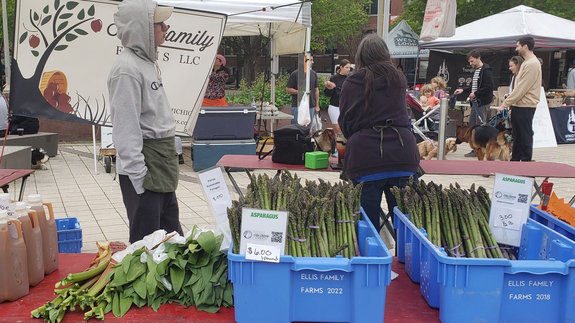 Photo of people at a farmers market selling asparagus