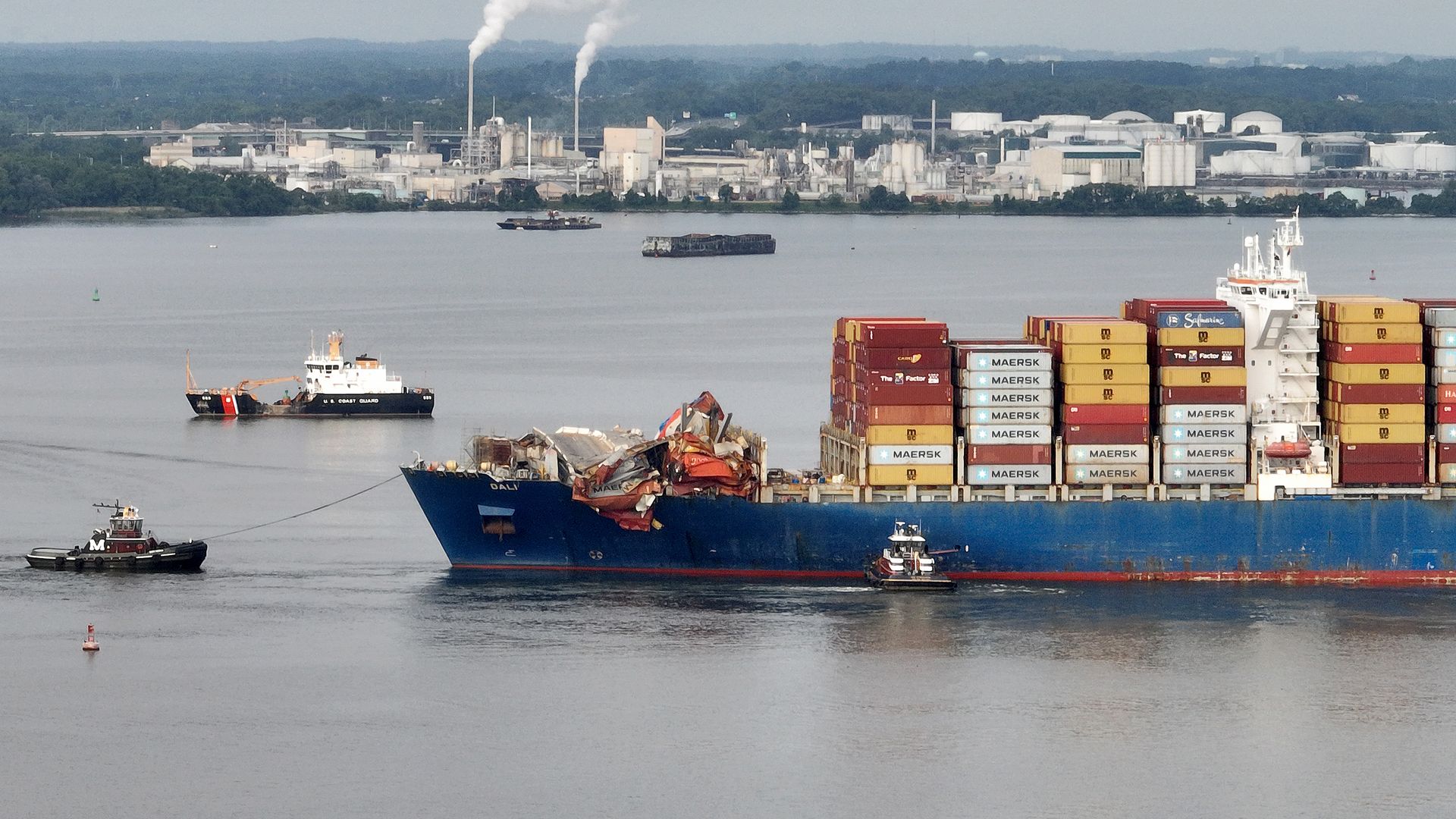 tug boats maneuver the damaged container ship Dali through the Port of Baltimore 