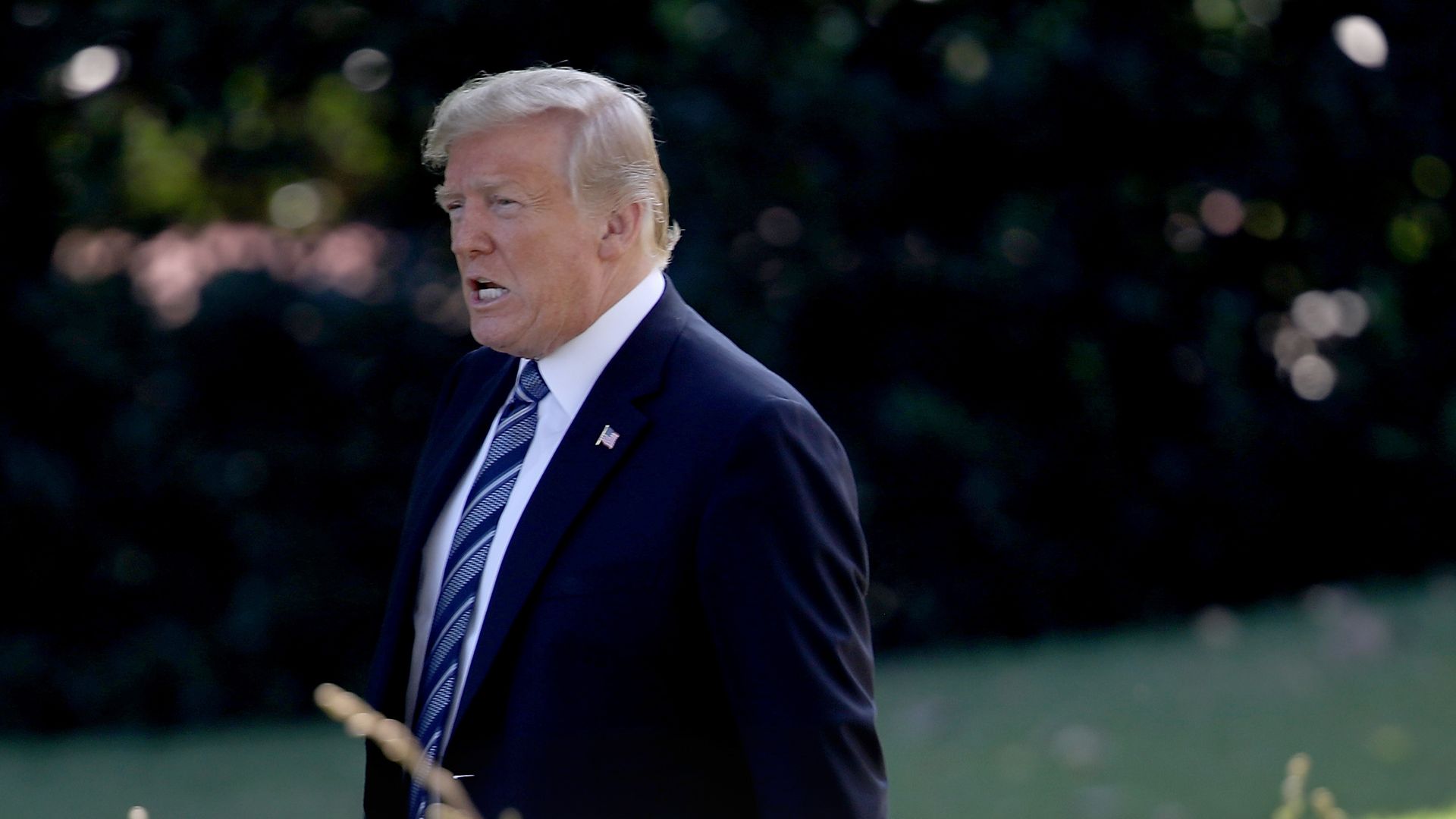 Donald Trump seemingly talking angrily while walking across the White House lawn