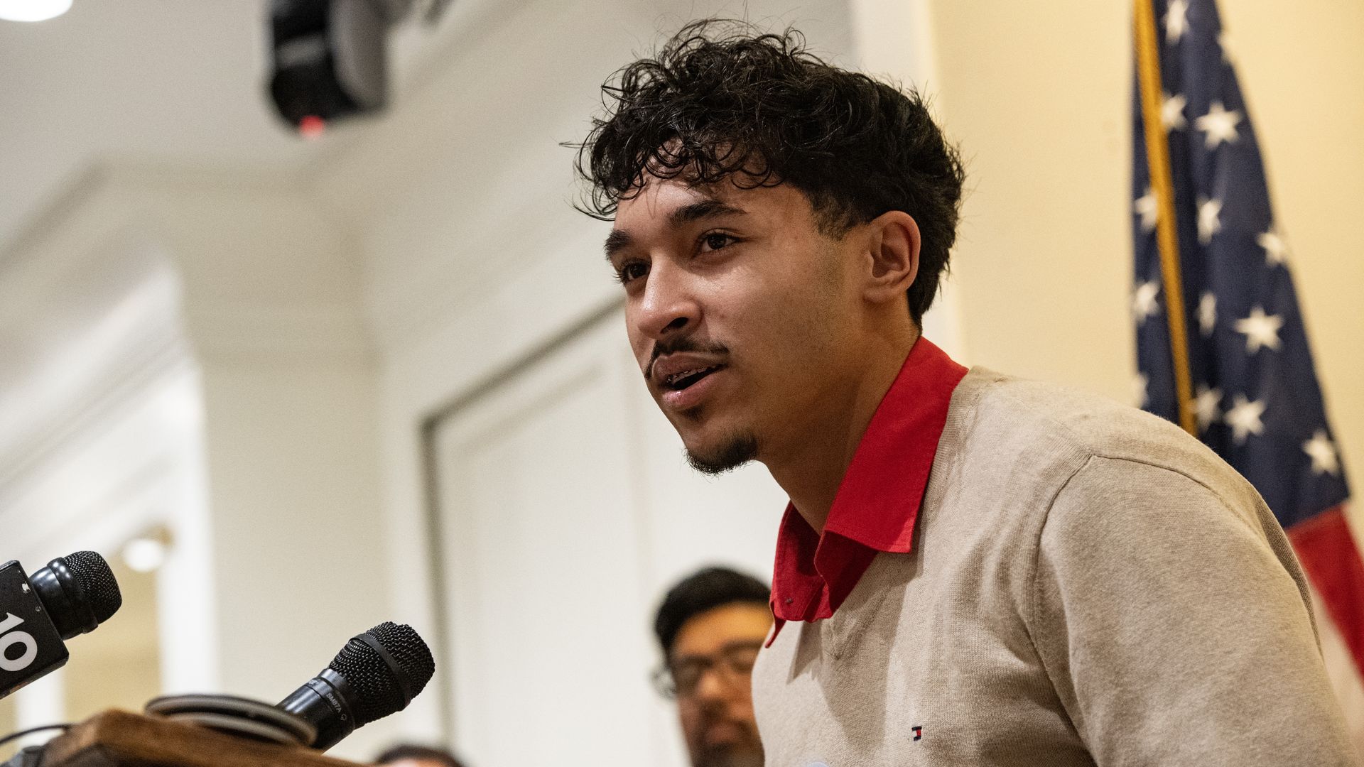 A close up at Marcelo Gomes da Silva, a teen who was arrested by ICE in May, standing at a lecturn speaking at a rally at the Massachusetts State House in November. 