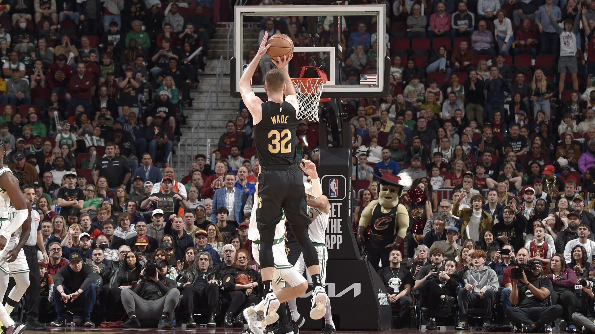 A photo of the Cavs' Dean Wade (black) shooting a 3-point shot from the back. 