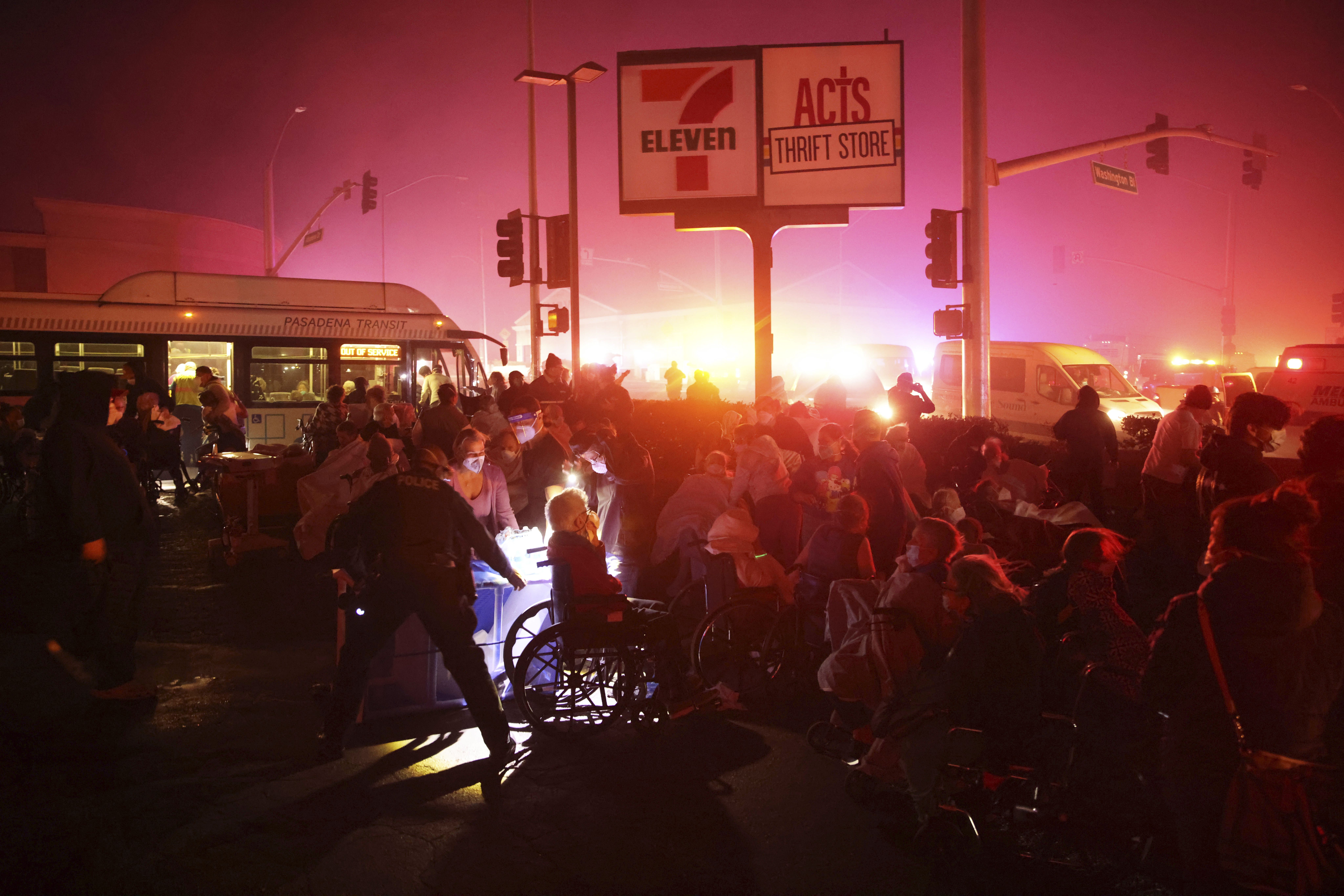 Residents of a senior center are evacuated as the Eaton Fire approaches Tuesday, Jan. 7, 2025, in Altadena, Calif. (AP Photo/Ethan Swope)