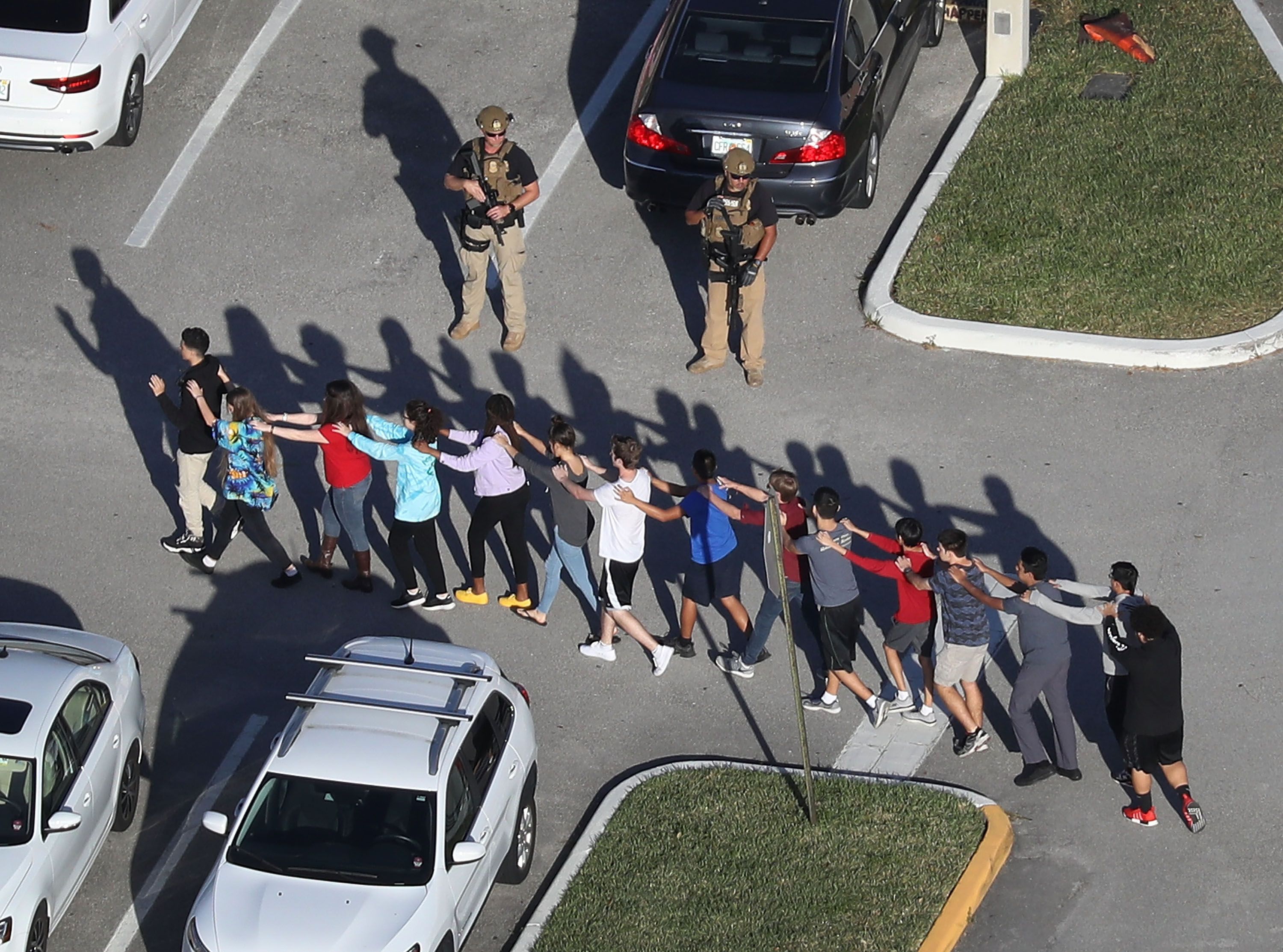 People are brought out of the Marjory Stoneman Douglas High School after a shooting at the school 