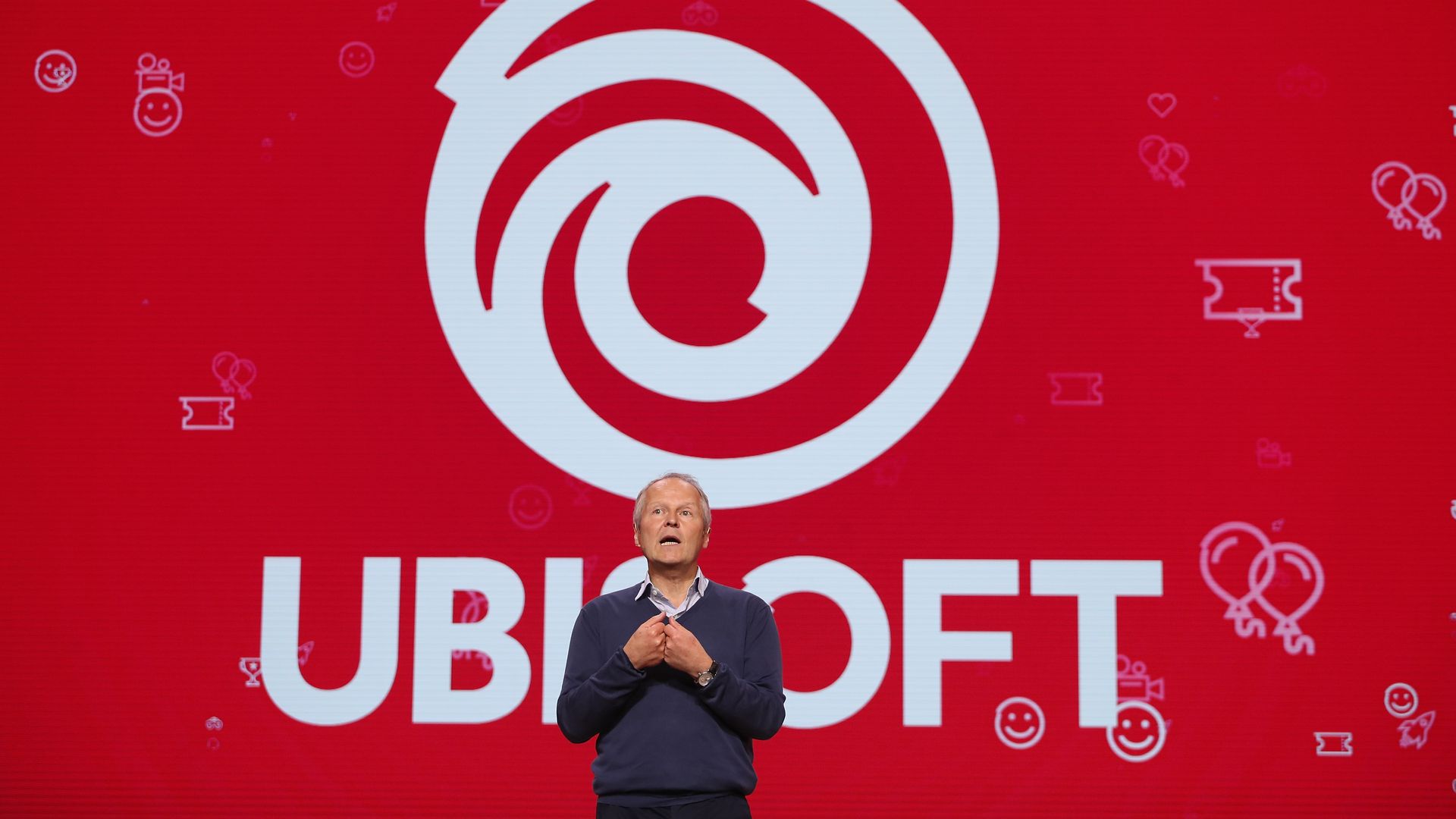 Ubisoft CEO Yves Guillemot in front of the company's logo.