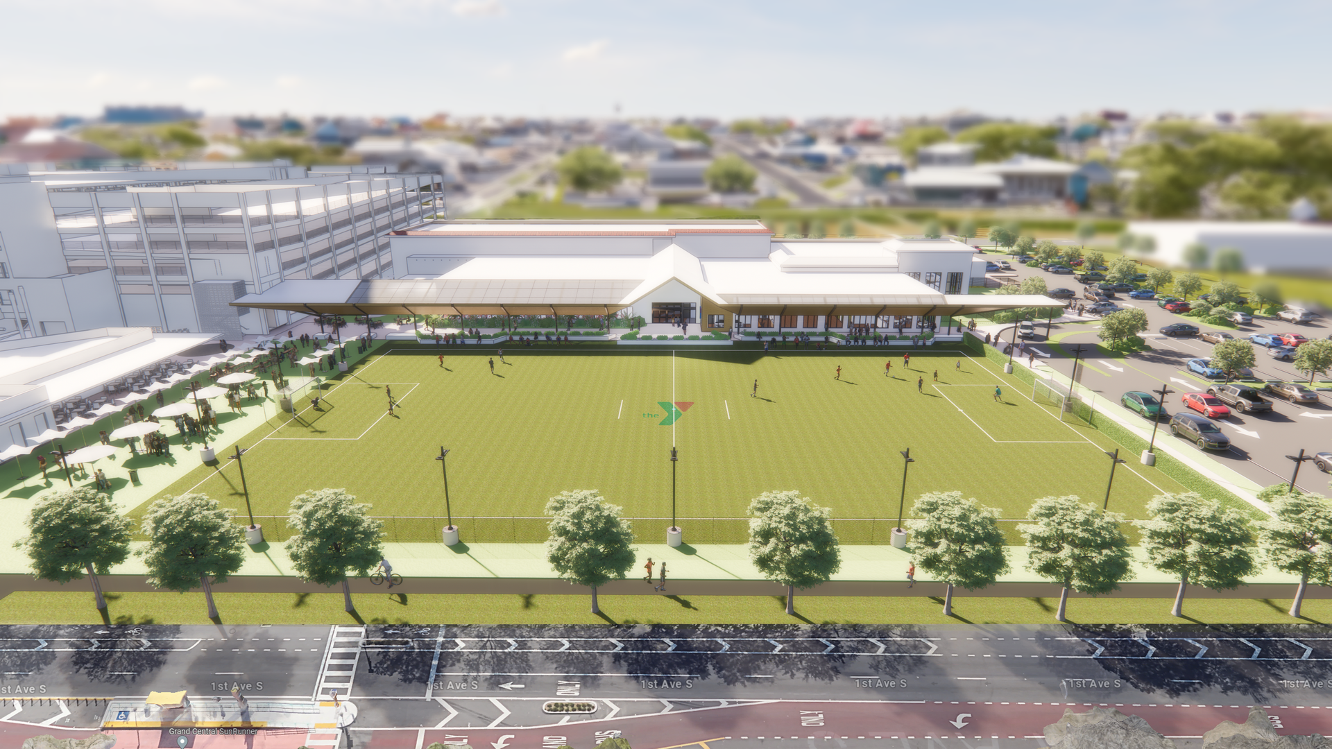 A rendering showing a giant green soccer field bordered by a building and a road.