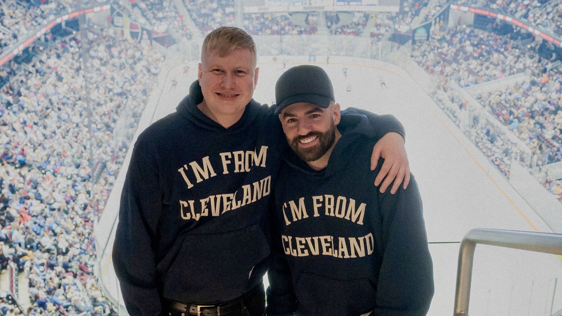 Two guys in I'm From Cleveland shirts pose for photos.