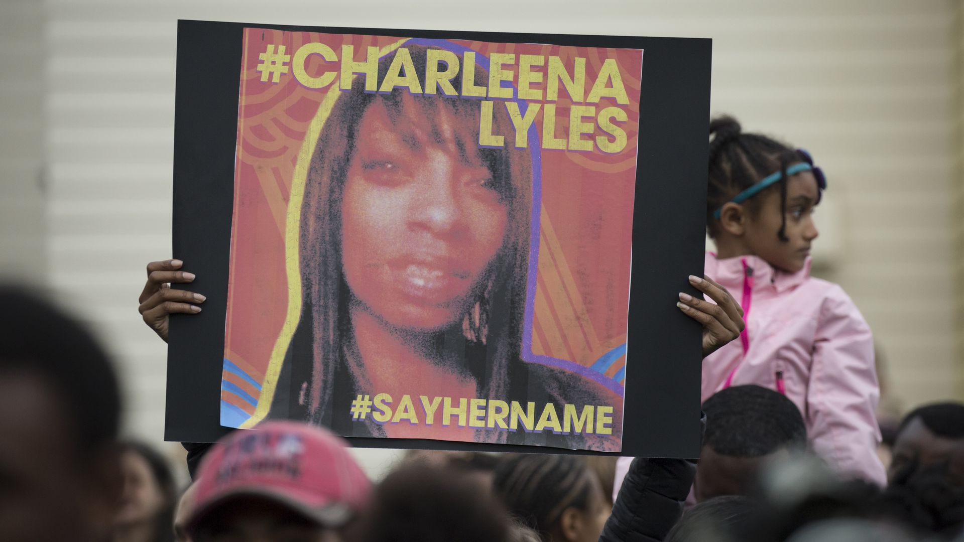 A protester holds a sign with an image of Charleena Lyles