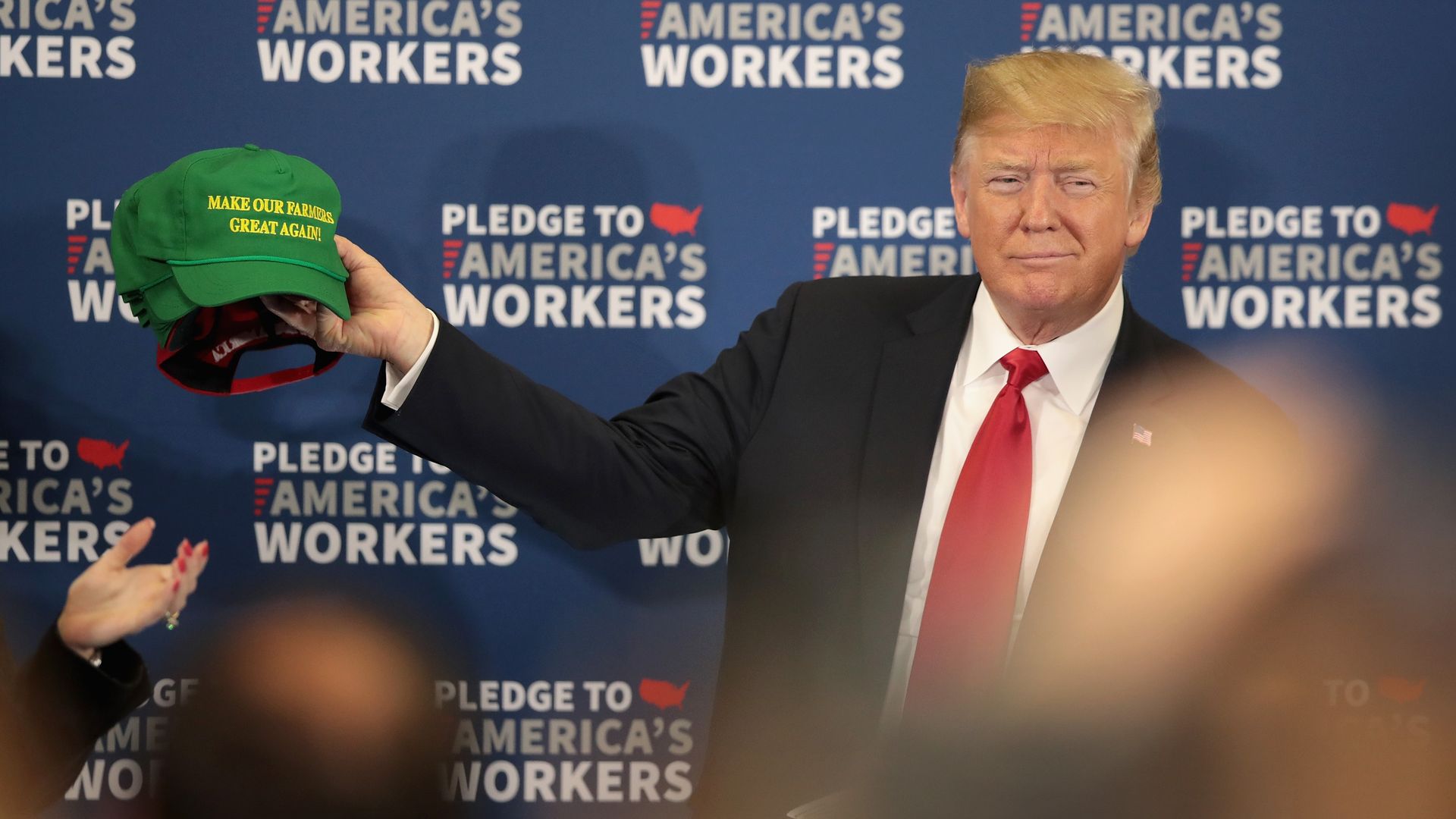 President Trump holding a green hat that says "Make Our Farmers Great Again"