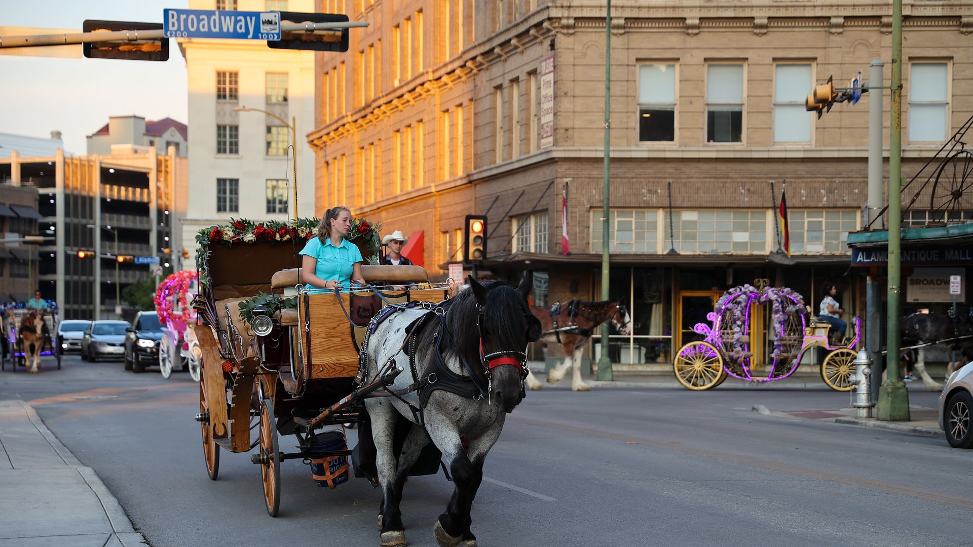 A horse-drawn carriage in front of the Broadway street sign in downtown San Antonio.