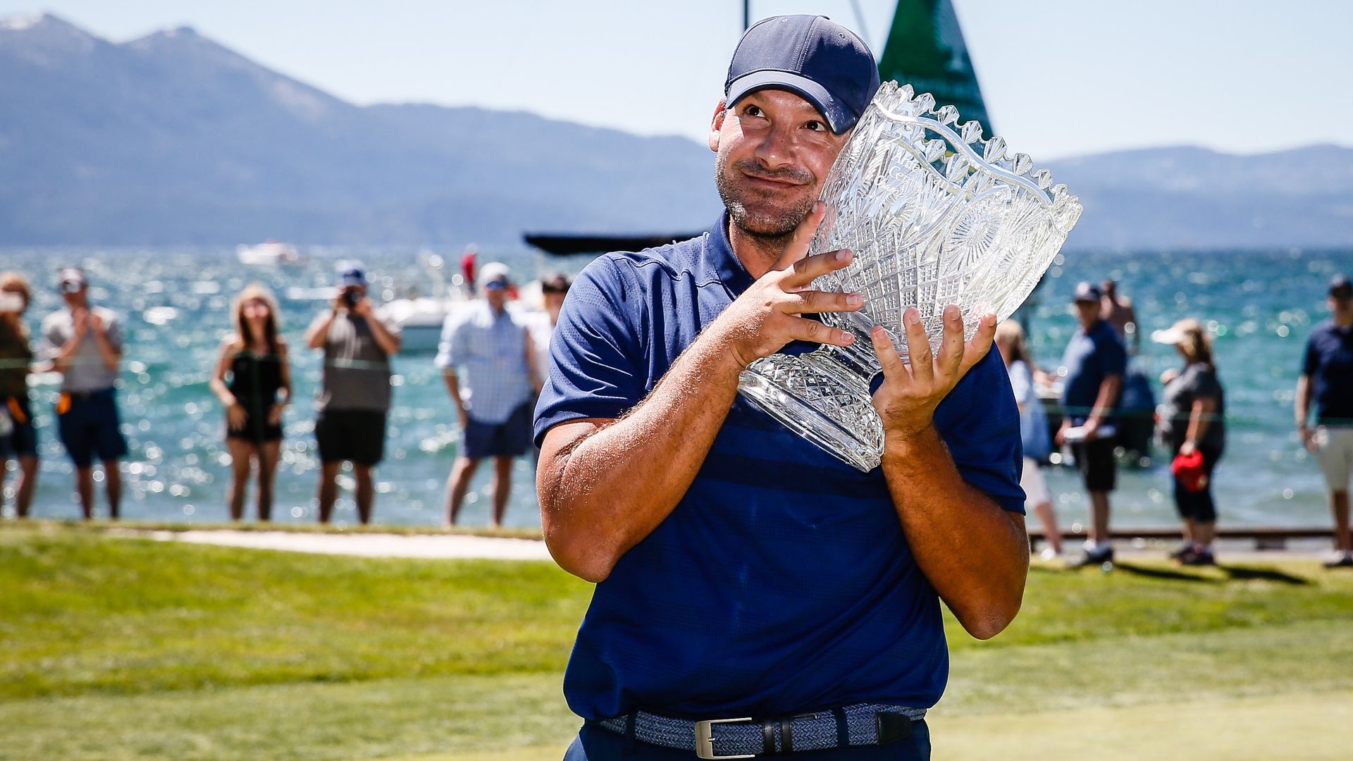 Tony Romo hugs the winner's trophy