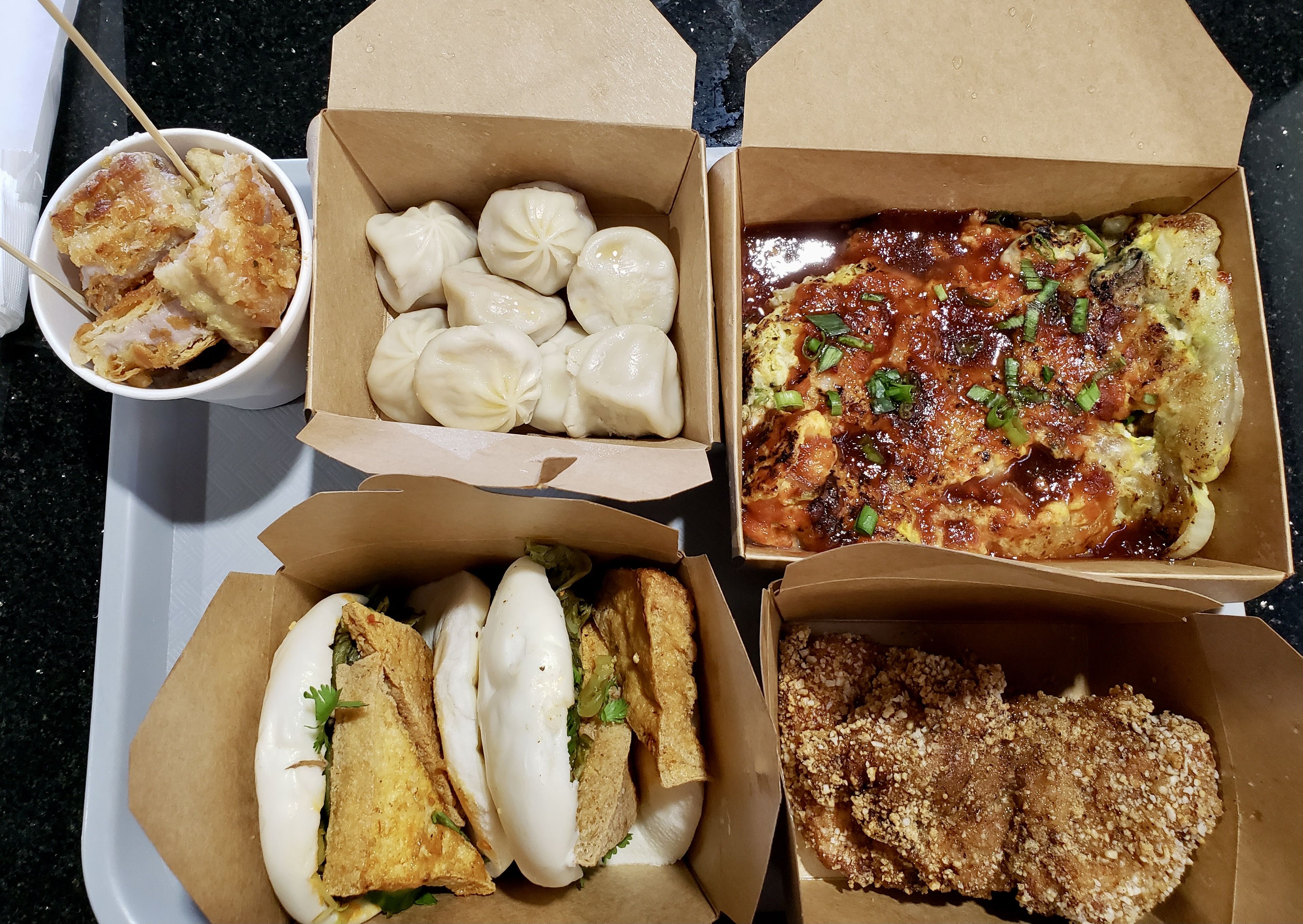 Five Taiwanese dishes in boxes on a tray. 