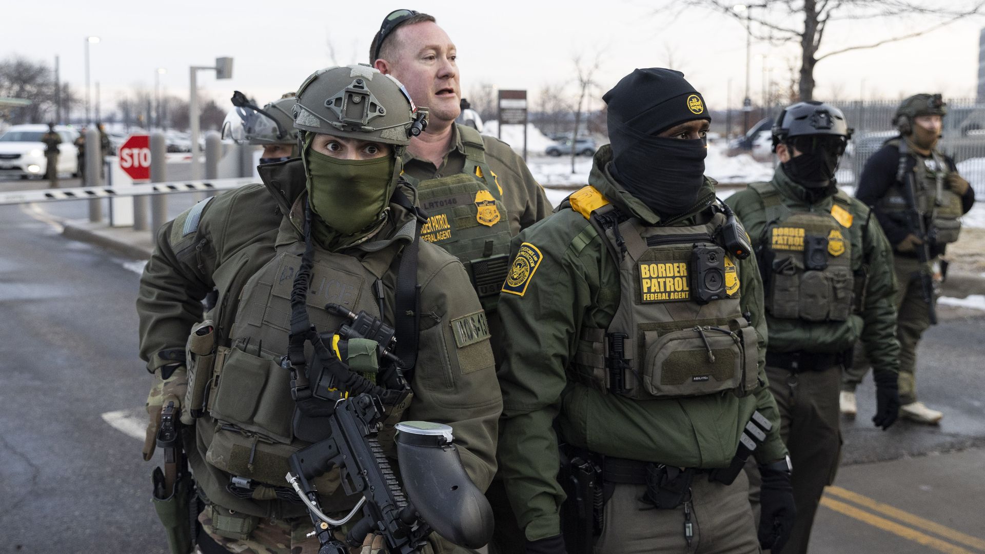 Federal law enforcement officers stand near a crowd of anti-ICE protesters outside an ICE facility in Minneapolis during demonstrations following the fatal shooting of Renee Good.