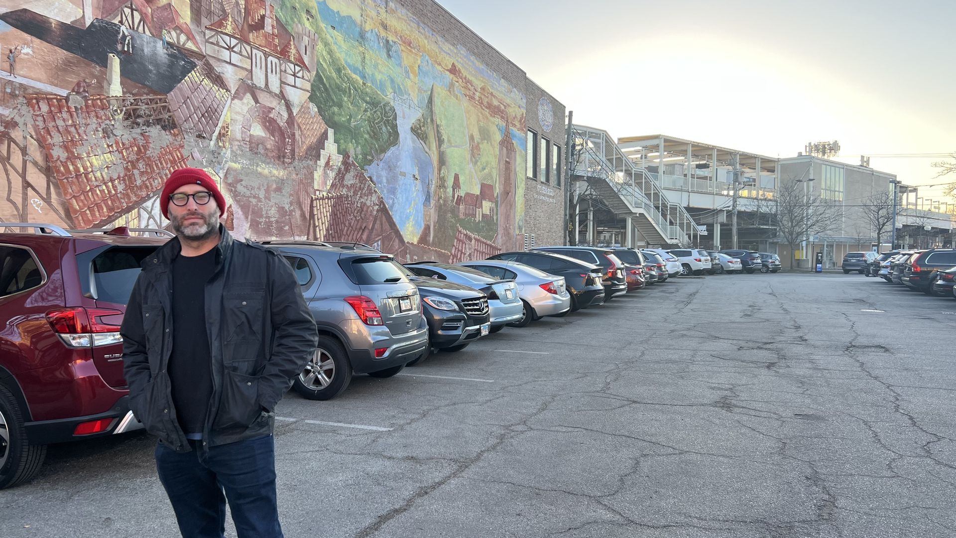 Photo of a man standing in front of a mural