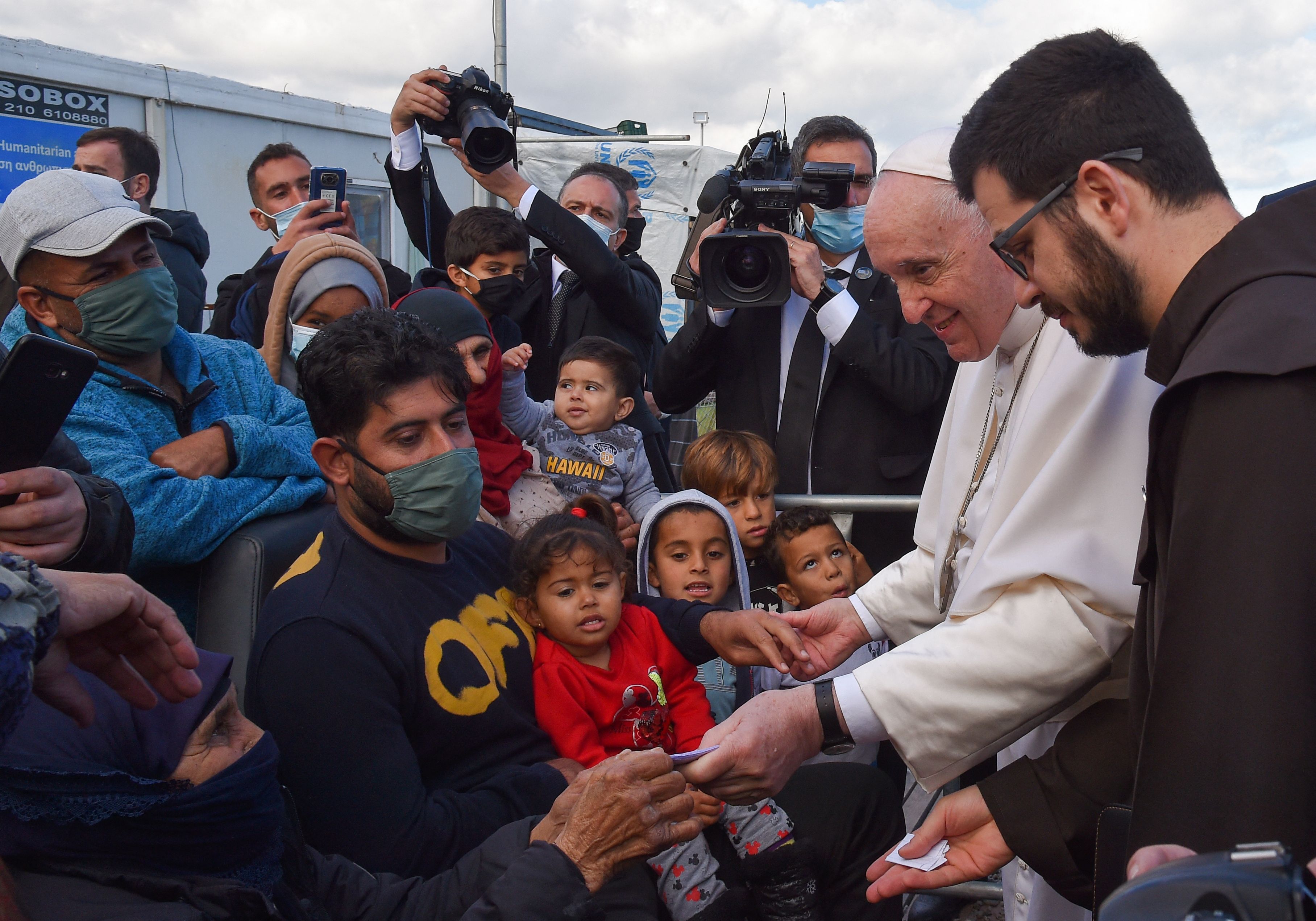 Pope Francis (2R) speaks with refugees at the Reception and Identification Centre (RIC) in Mytilene on the island of Lesbos on December 5
