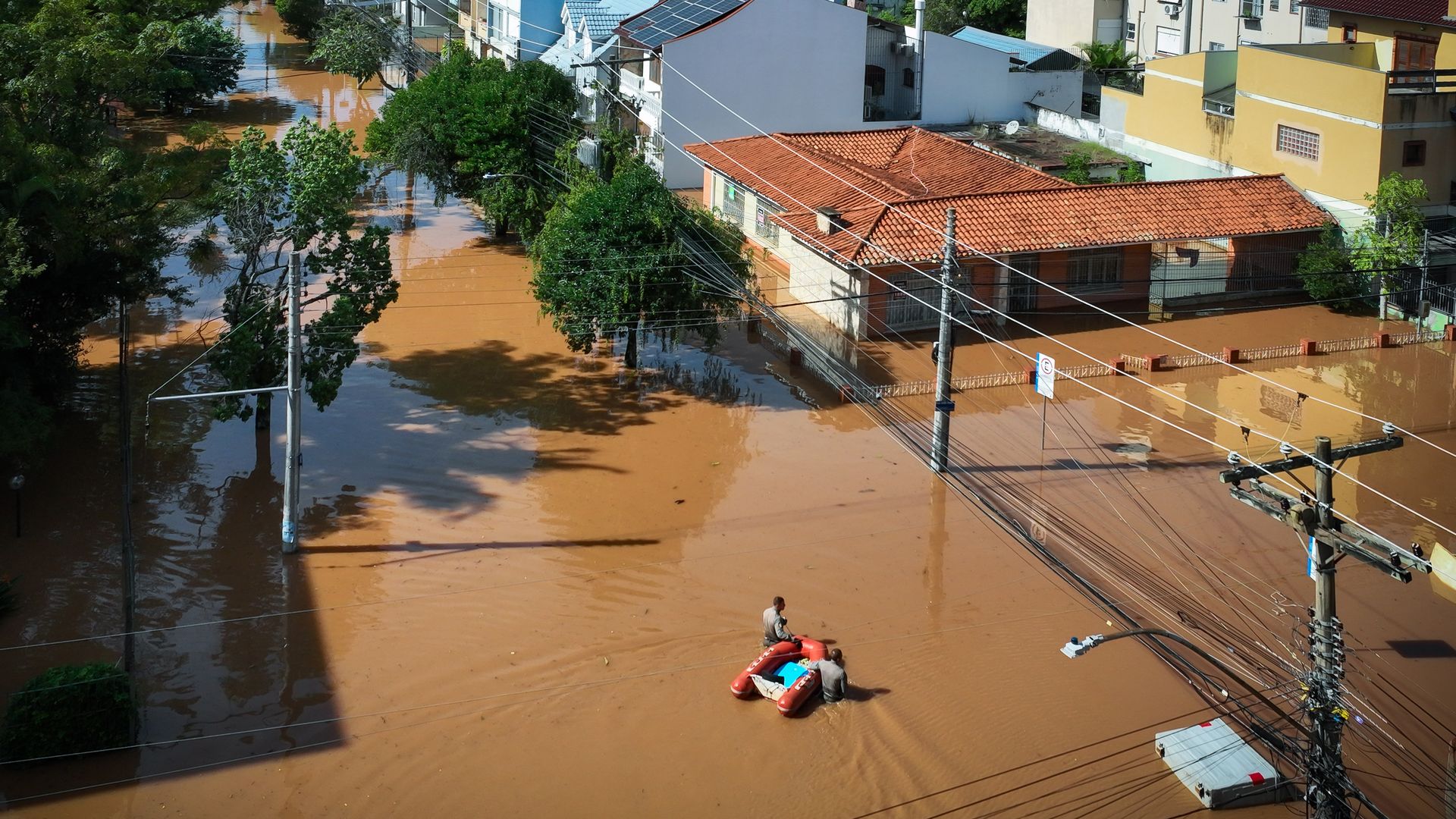 An aerial shot of a rescue team wading through high water in Brazil. 