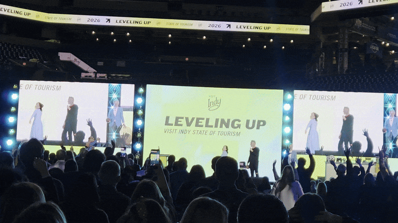 Colts owner Kalen Jackson, Pat McAfee and Visit Indy executive vice president Chris Gahl throw footballs into the crowd during Visit Indy’s annual State of Tourism event.