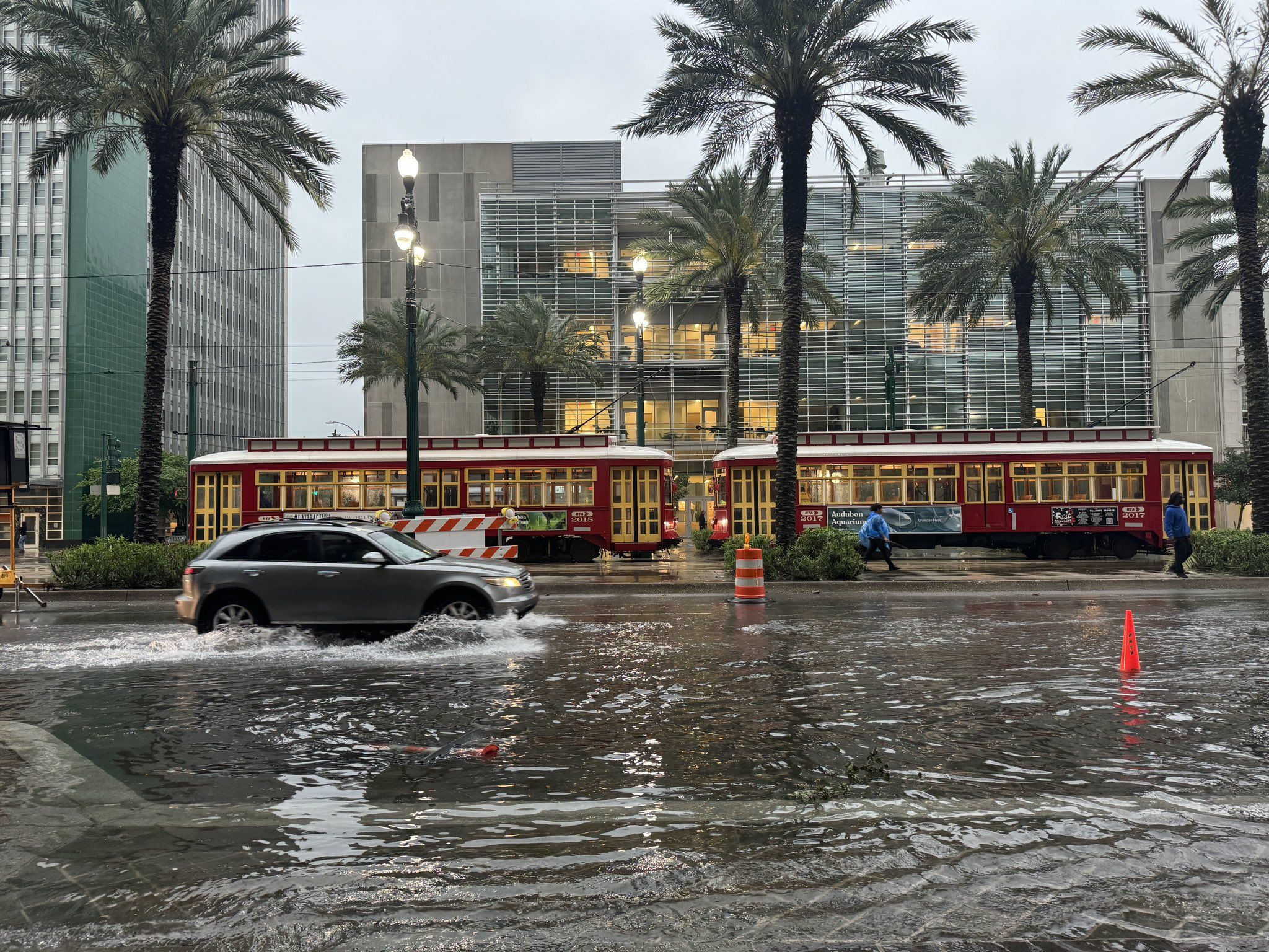 Photo shows an SUV driving through Canal Street while it is flooded.