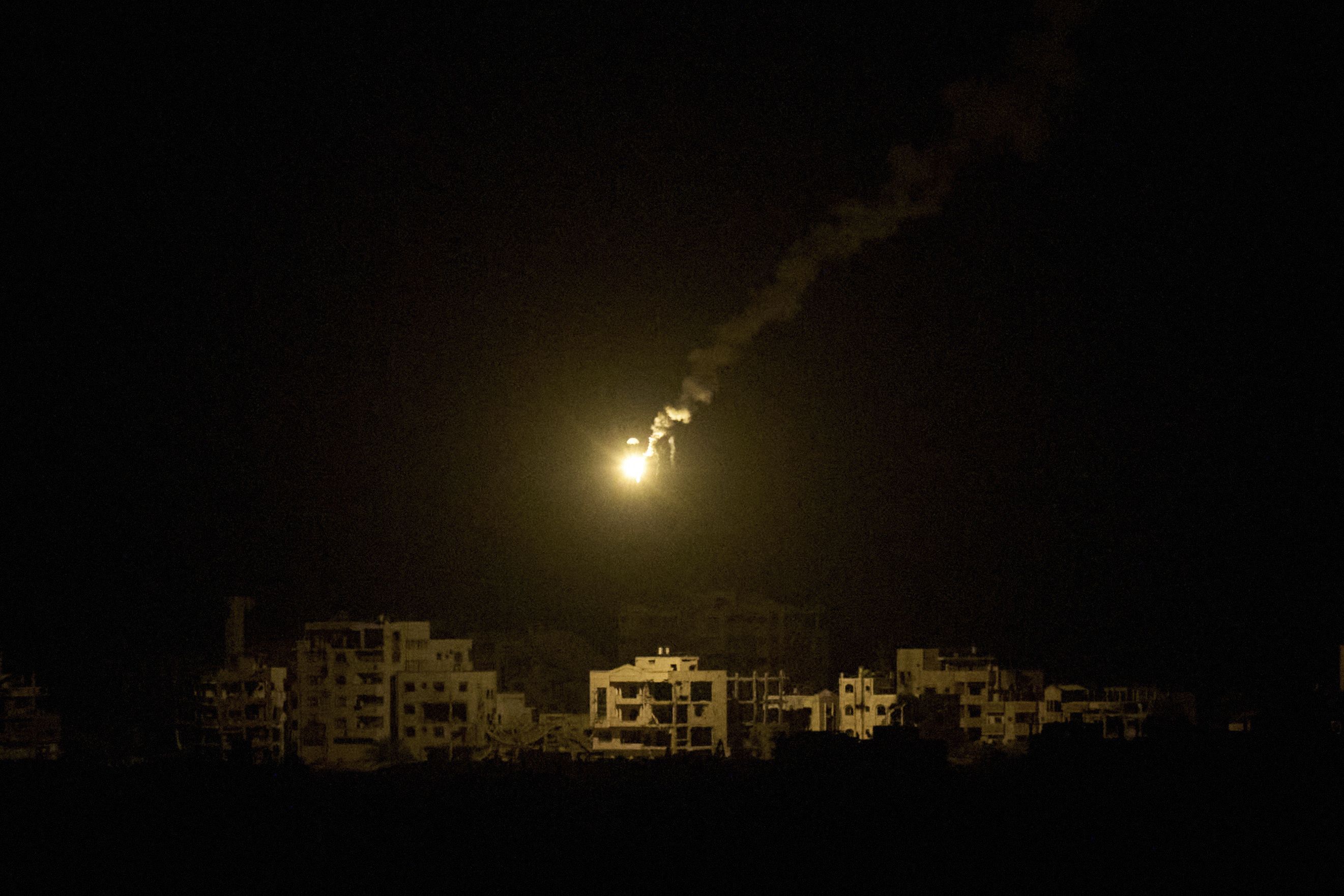 An Israeli army flare drifts over buildings destroyed during the Israeli ground and air operations in the northern Gaza Strip, as seen from southern Israel, Monday, Sept. 15, 2025. (AP Photo/Leo Correa)