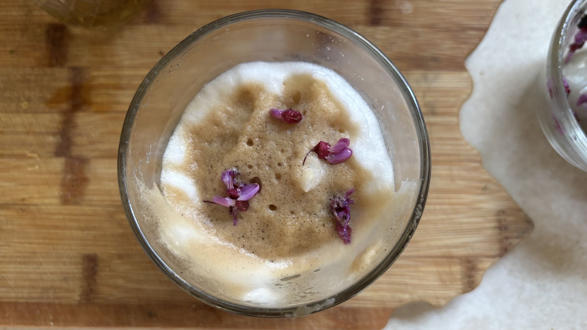 A latte made with redbud syrup and sprinkled with flowers from the Eastern redbud tree