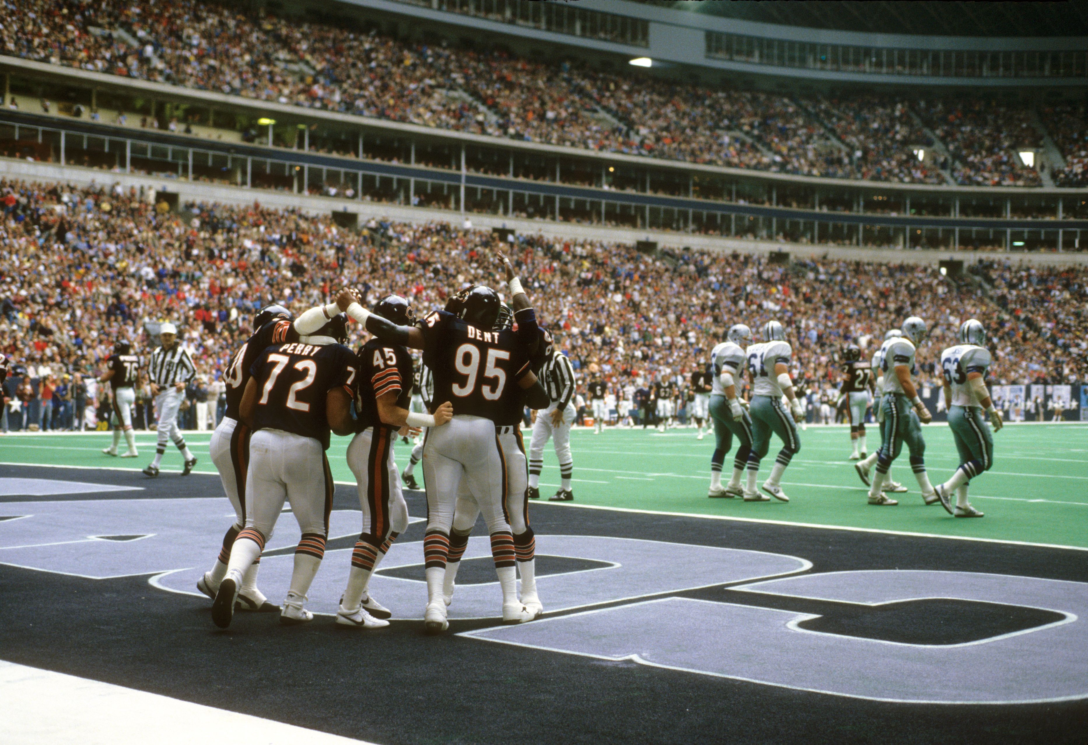 zone during a packed stadium football game against Dallas Cowboys in white jerseys and blue pants.
