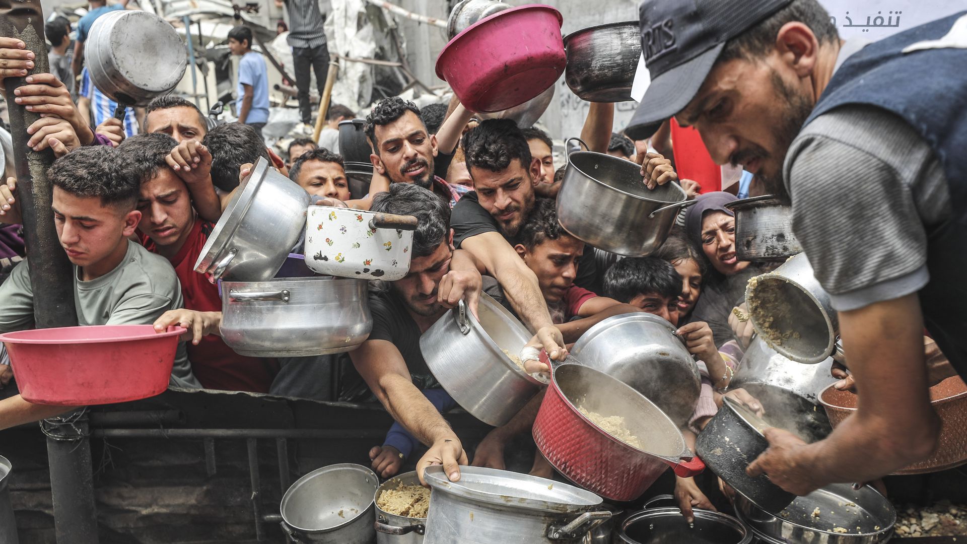 people strugglign to get food in a crowd