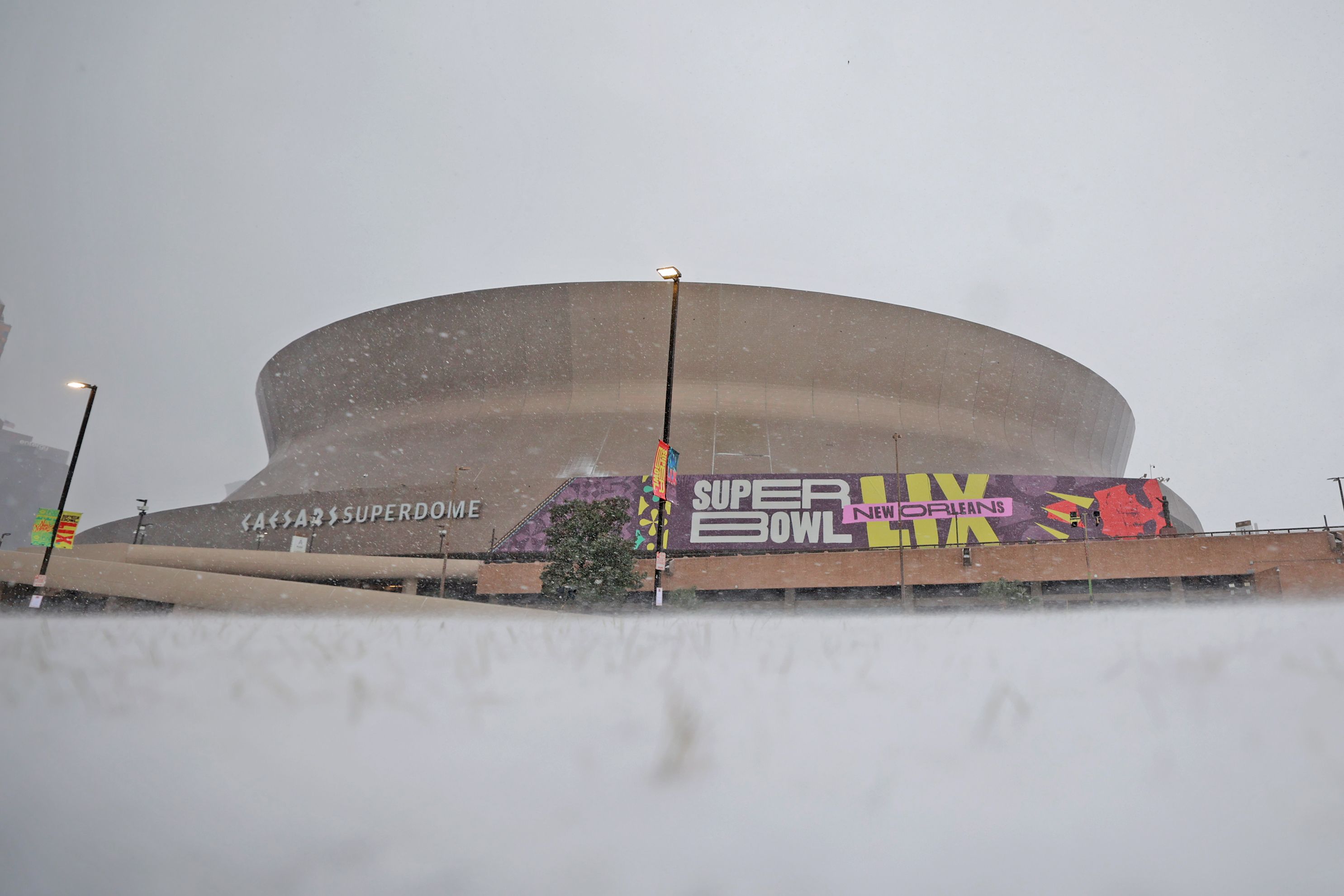 The Superdome sits under a grey sky in the snow.