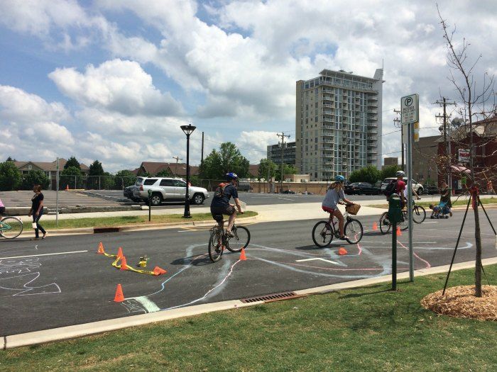 Cyclists riding a mini chalk course at Open Streets 704