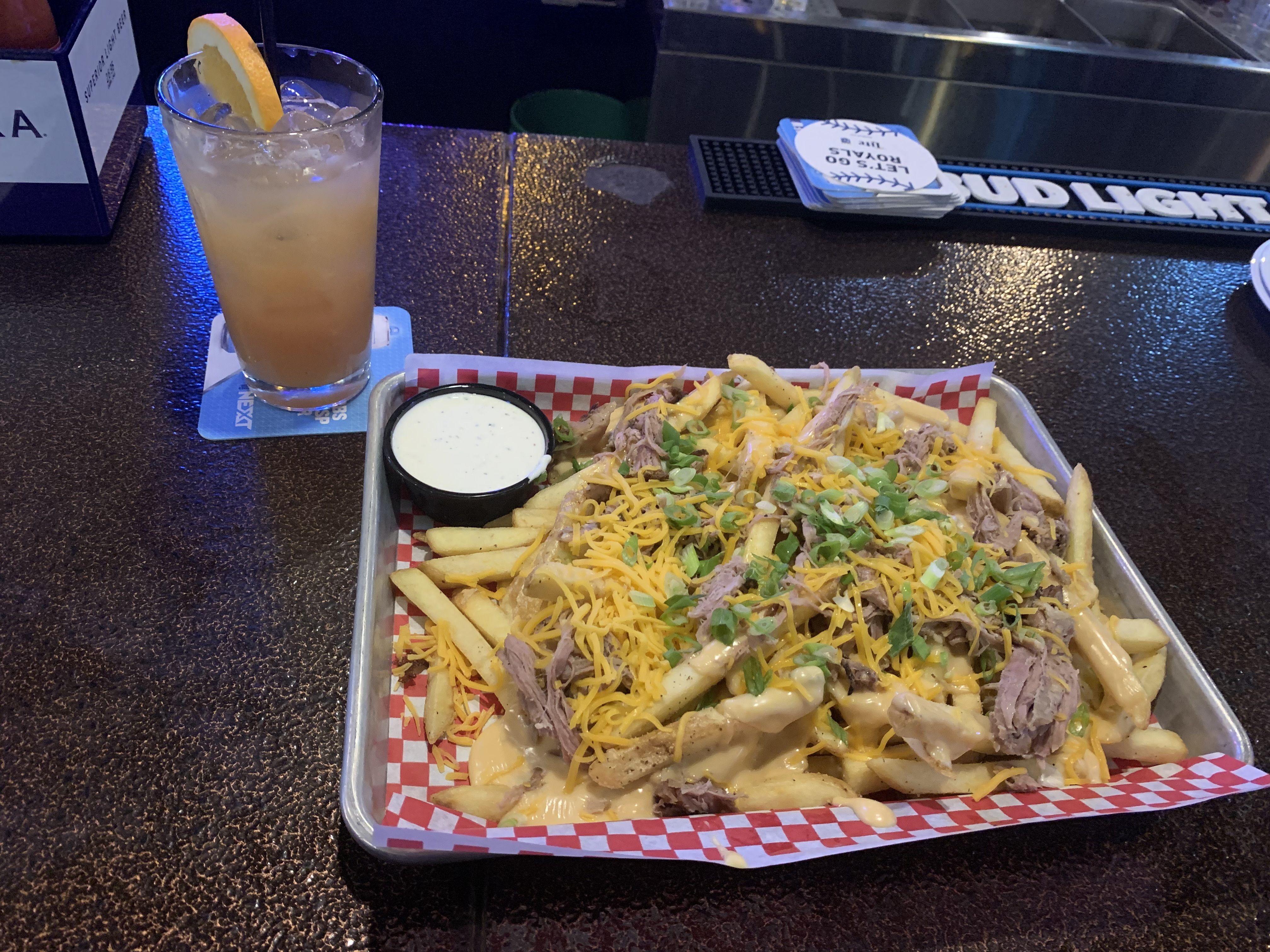Cocktail and cheese fries with pulled pork