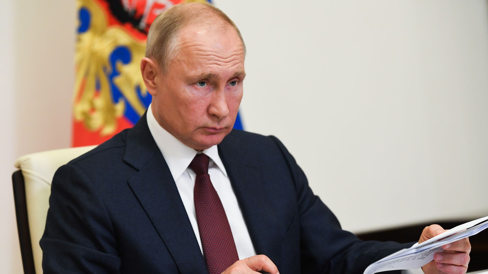 In this image, Putin sits at a desk