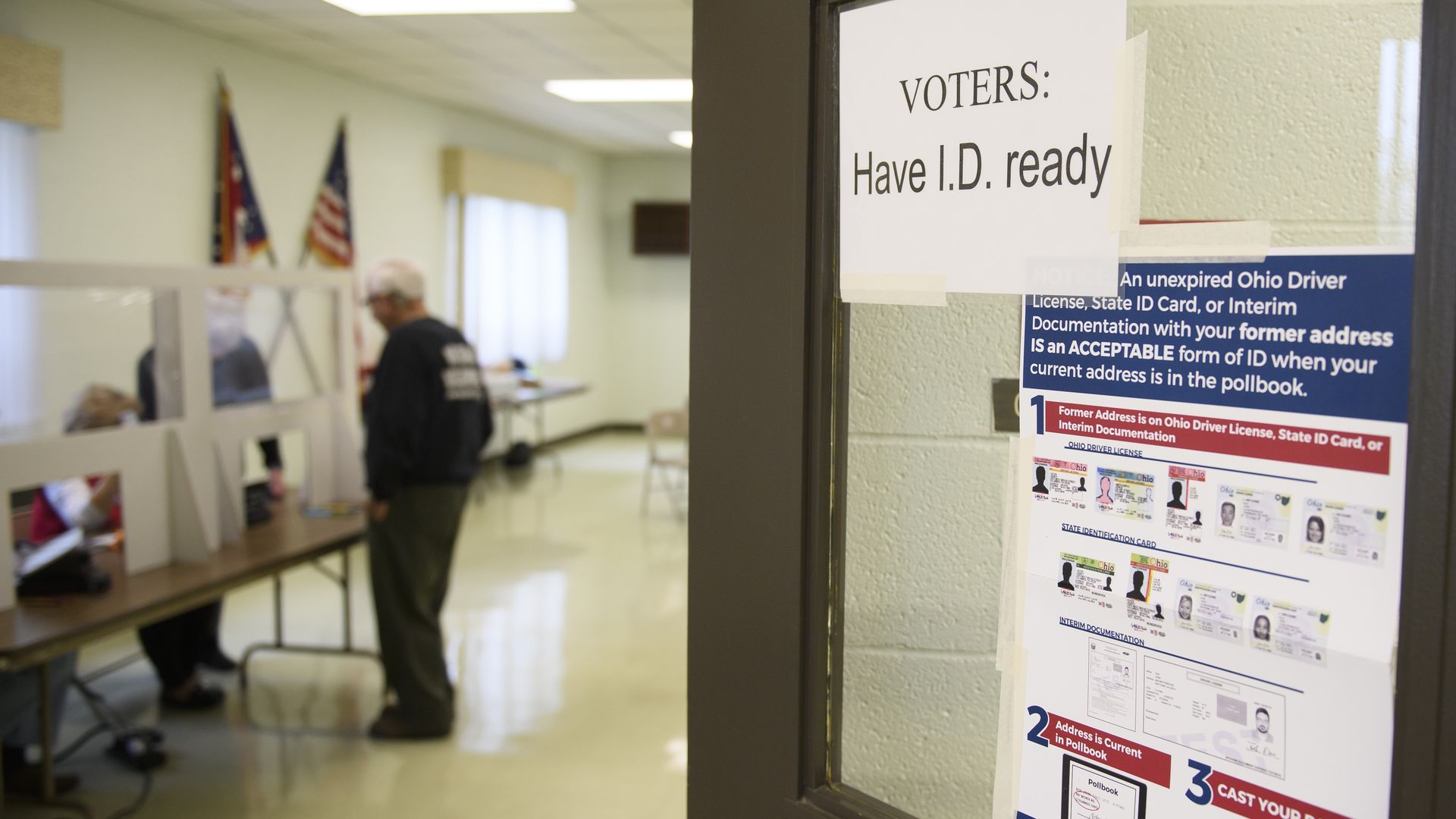 An Ohio voting precinct with a sign on the wall reading, "Voters: Have I.D. ready"