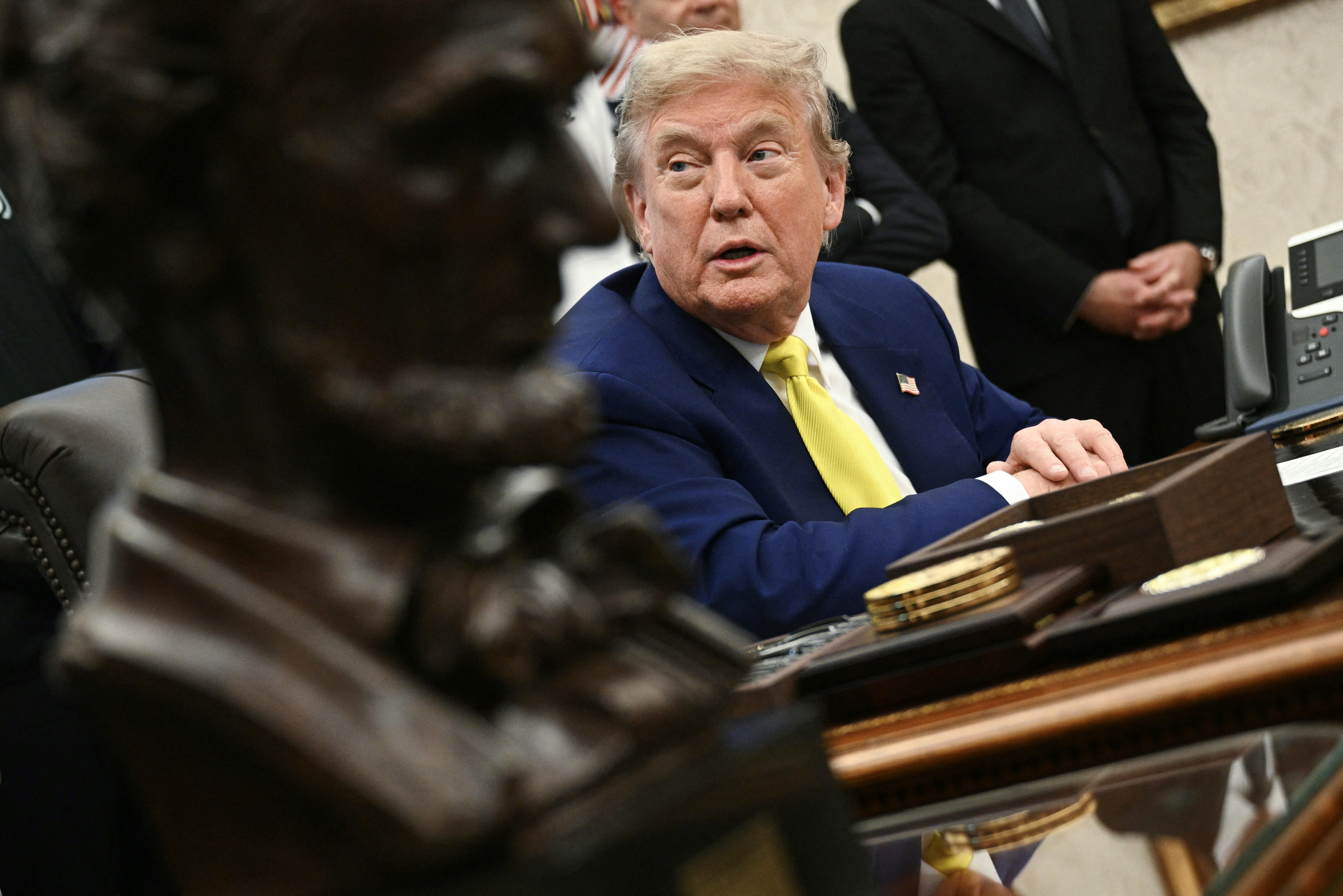Donald Trump speaks to the press in the Oval Office of the White House as members of Italian soccer club Juventus pay a visit in Washington, DC.
