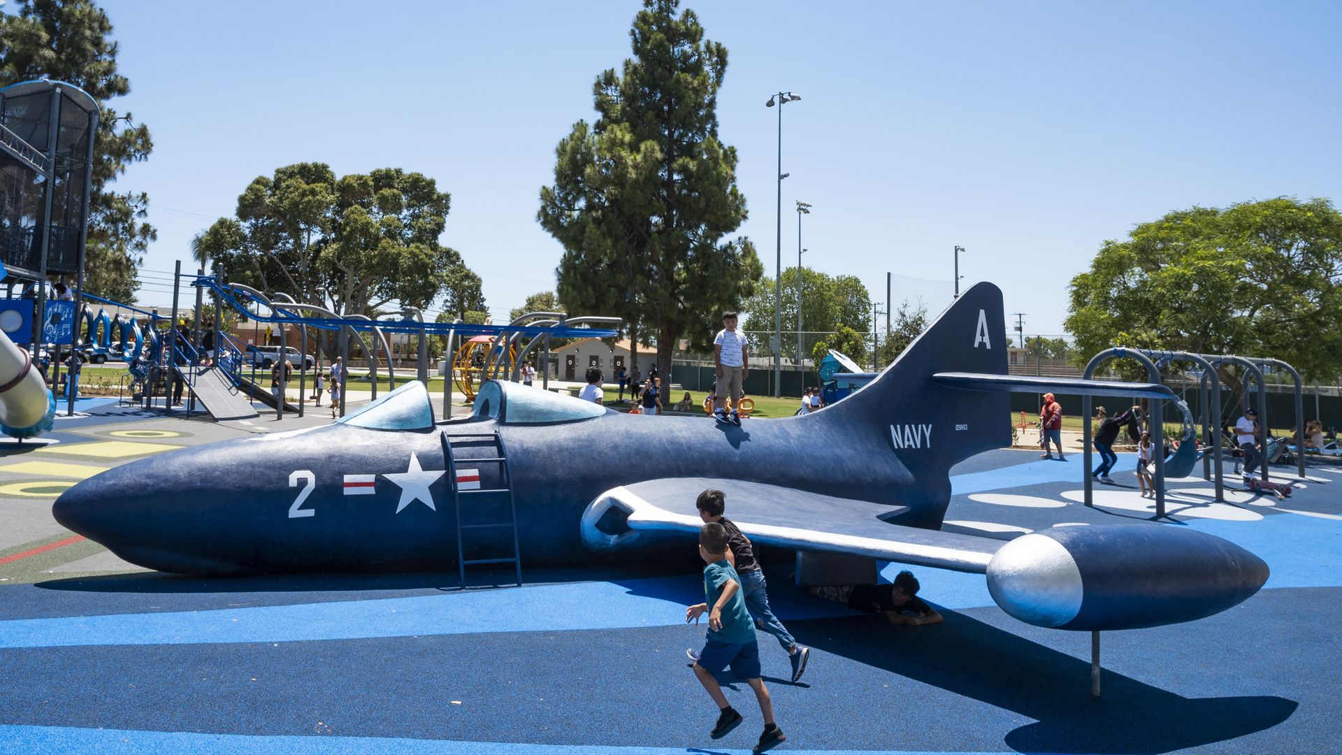 Photo of small children playing on a airplane structure on a playground