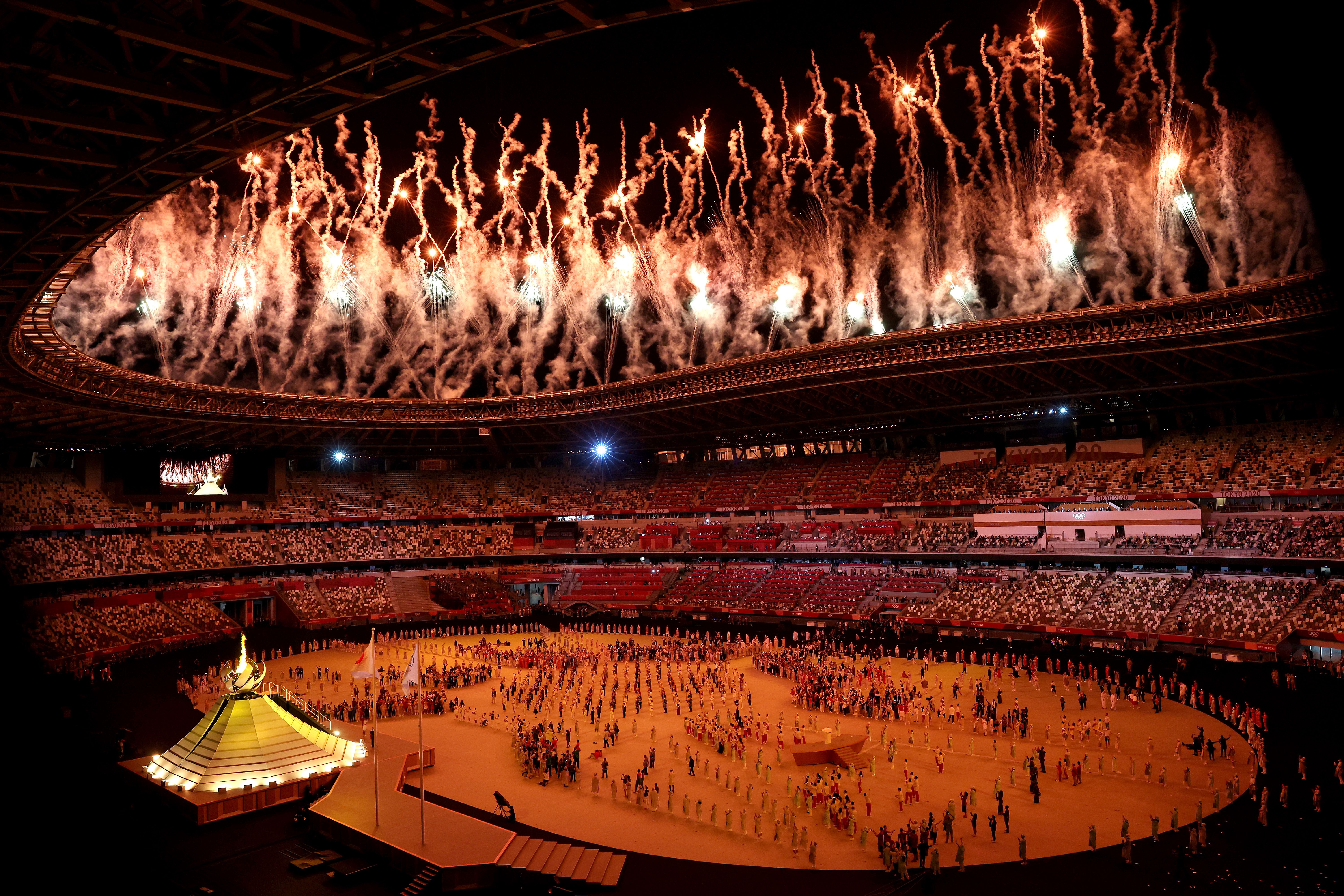 Picture of the Olympic stadium with fireworks going off celebrating the lighting of the cauldron