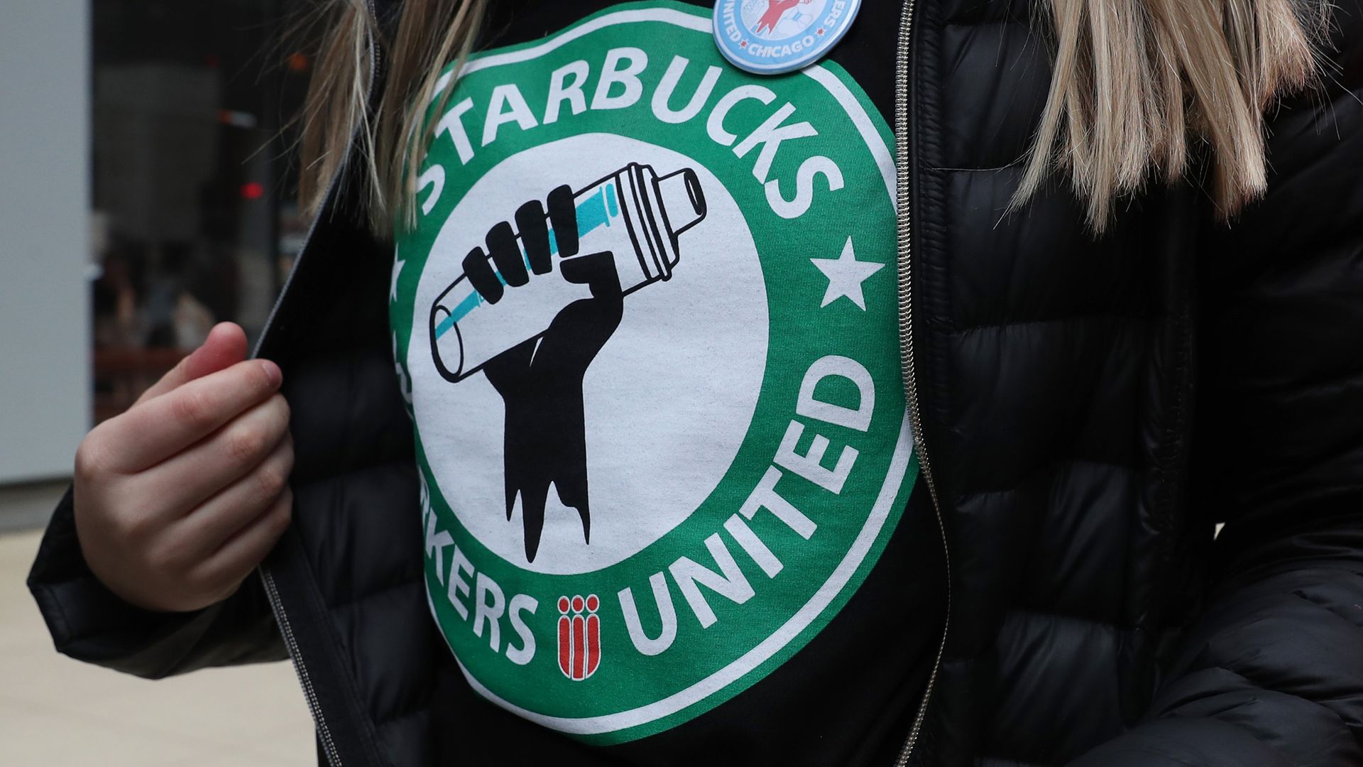 A Starbucks worker wears a t-shirt and button promoting unionization