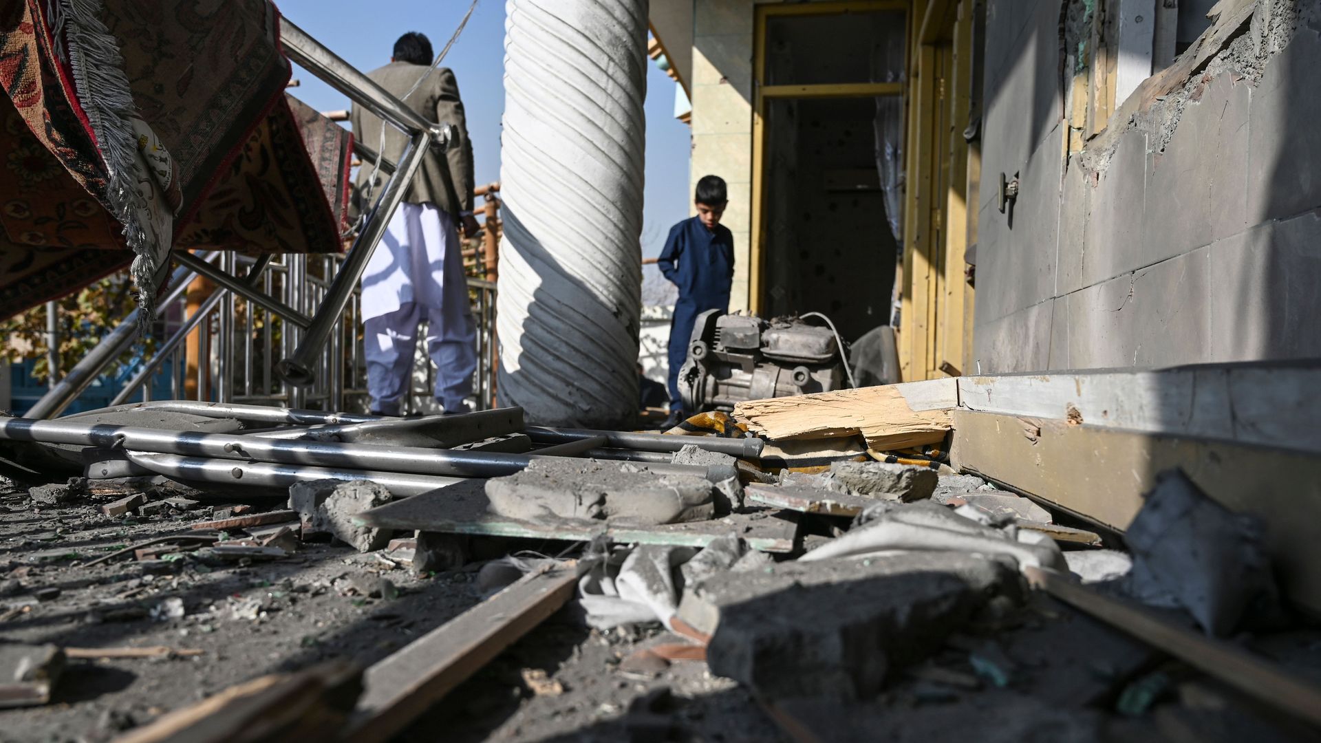 People inspect a damaged home in Kabul on Nov. 21 after several rockets struck the city.