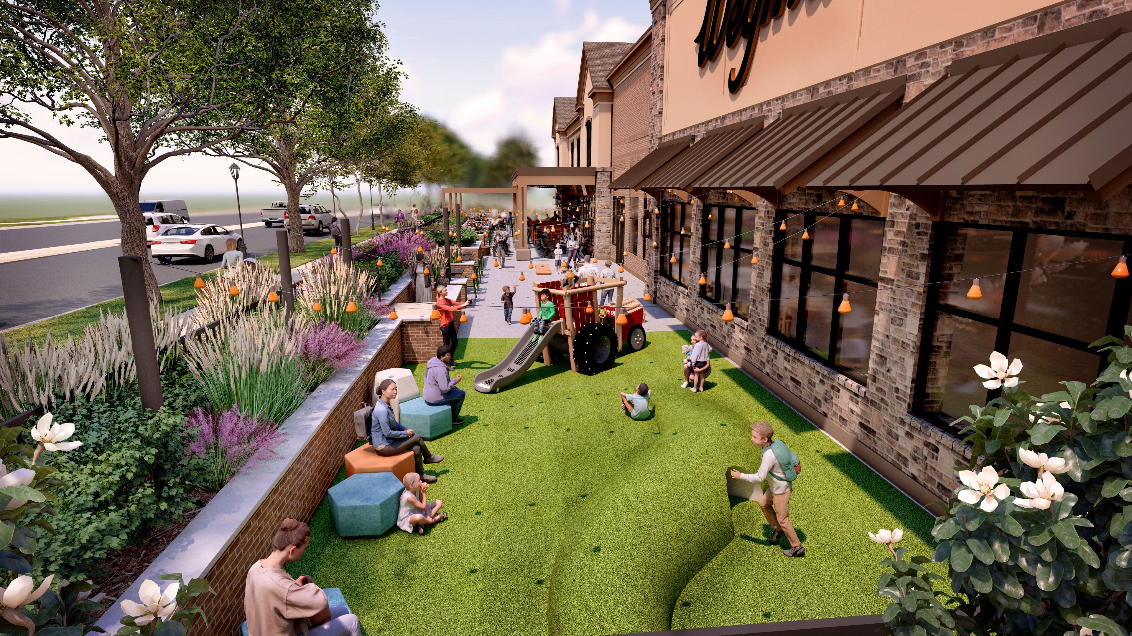 Outdoor play and seating area with artificial green turf, children playing on tractor slide, adults sitting on colorful stools, brown brick building with awnings, string lights, and flowers.