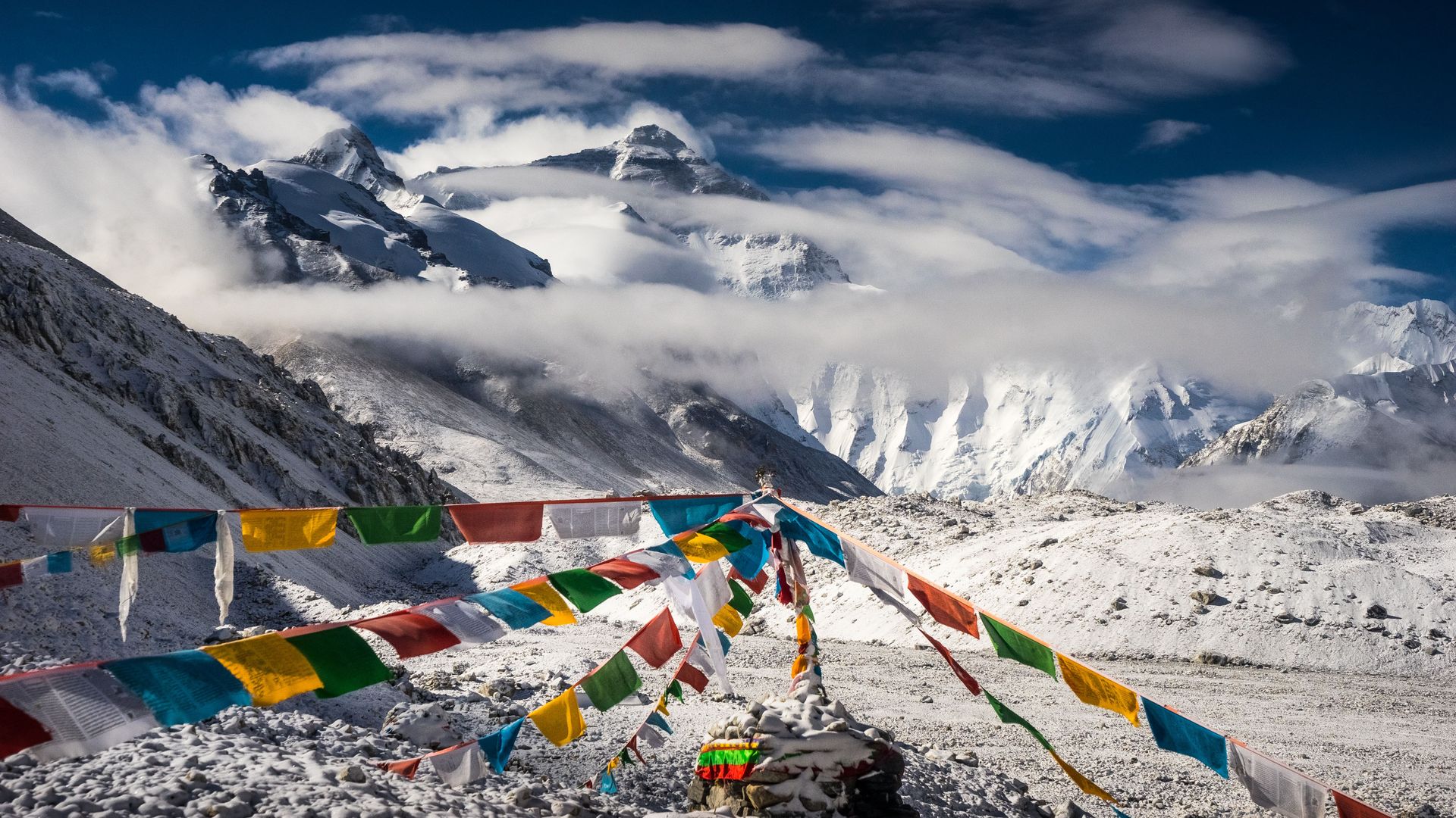 Tibetan prayer flags hang between snowy peaks