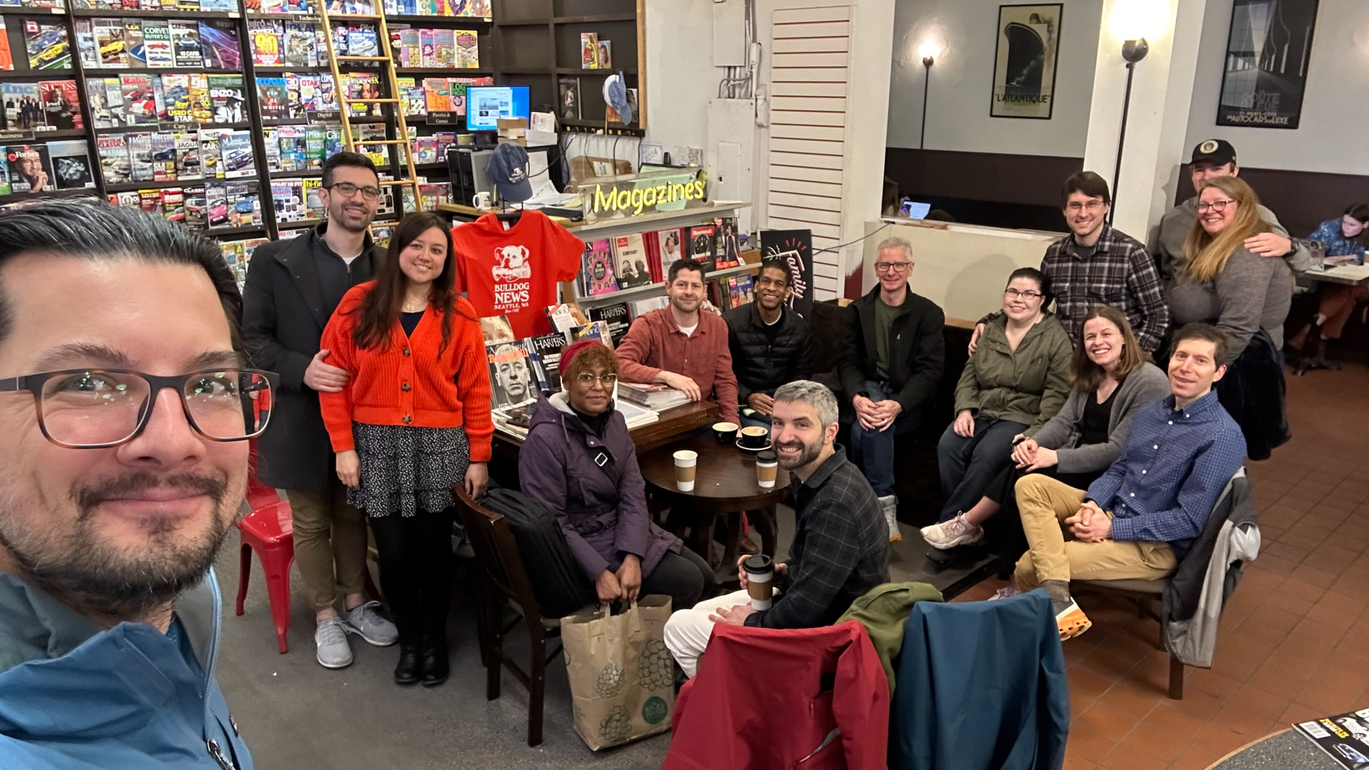 A group of people in a Seattle coffee shop smile for a selfie. 