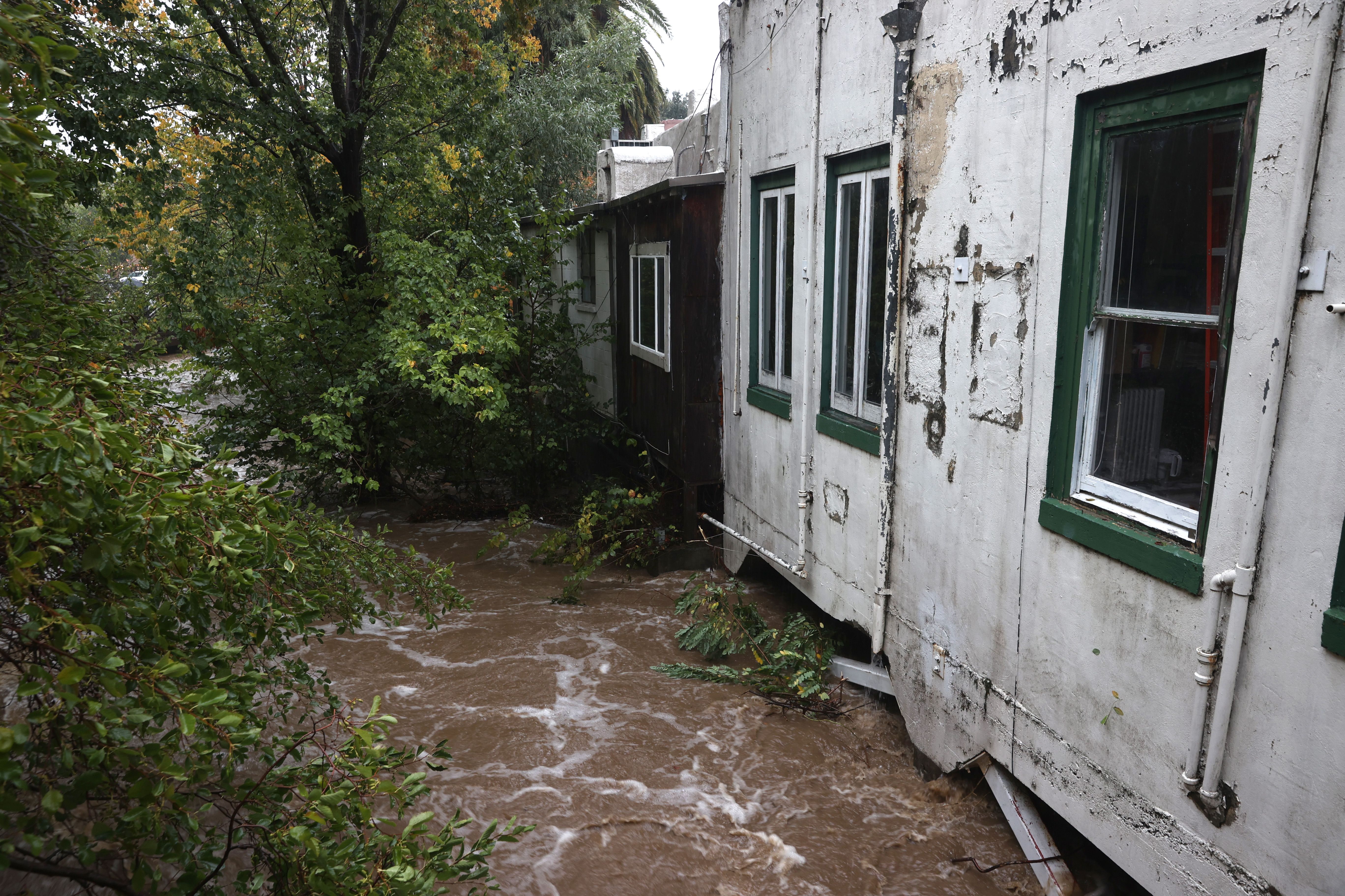  The swollen San Anselmo creek touches the bottom of businesses on October 24, 2021 in San Anselmo, California. 