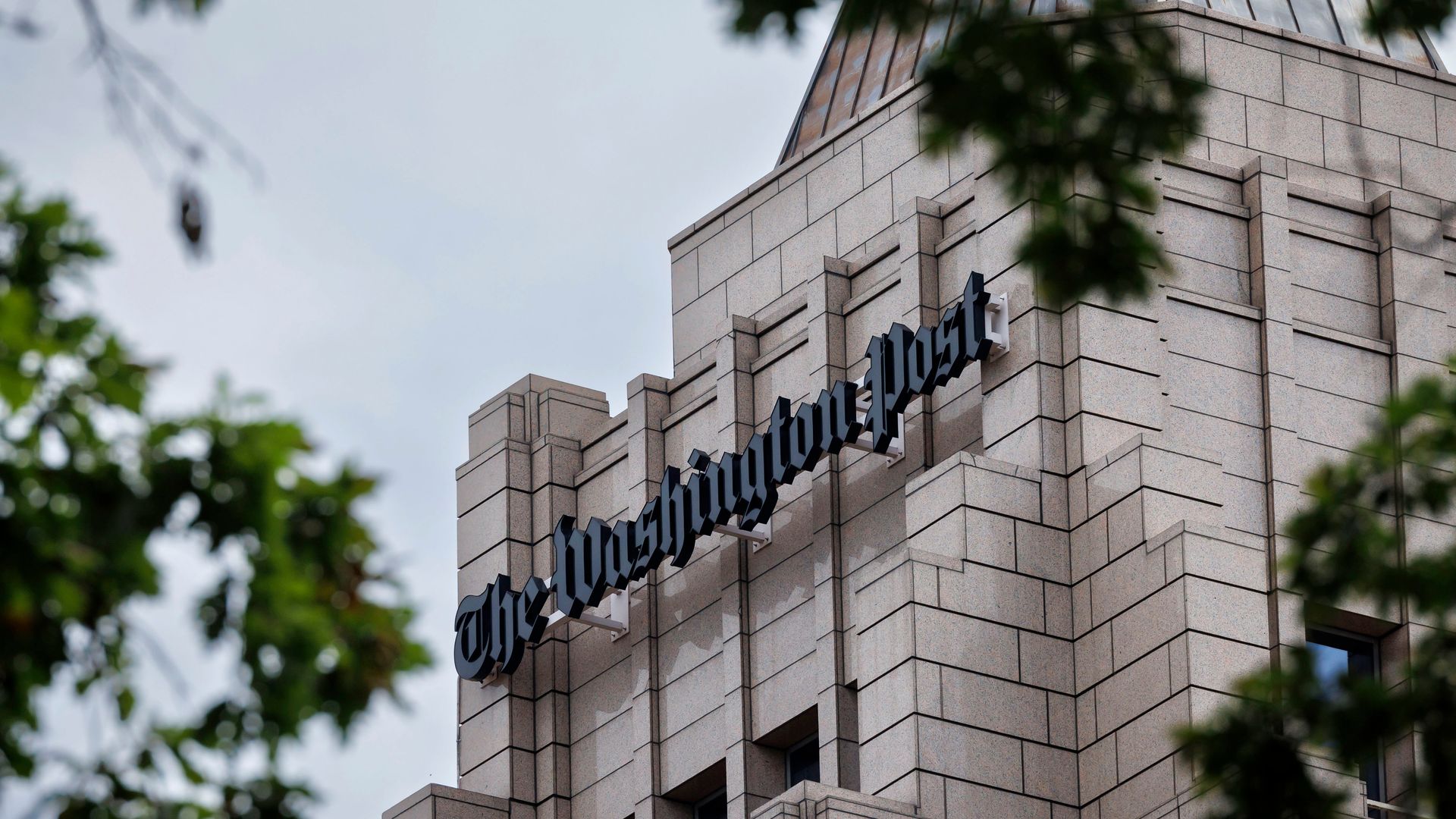 A photo of the Washington Post building with trees in the foreground