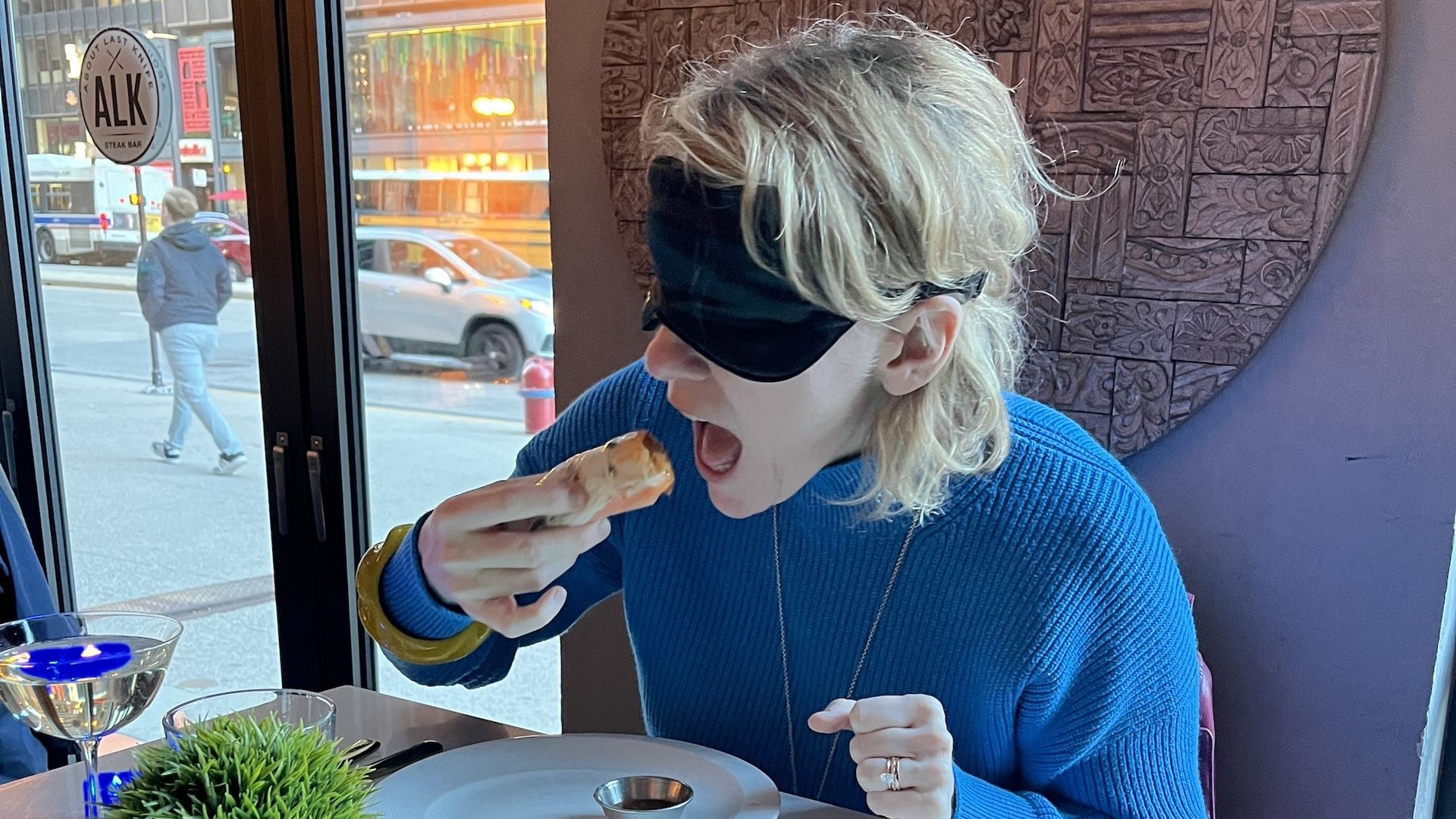 Photo of woman eating with blindfold on 