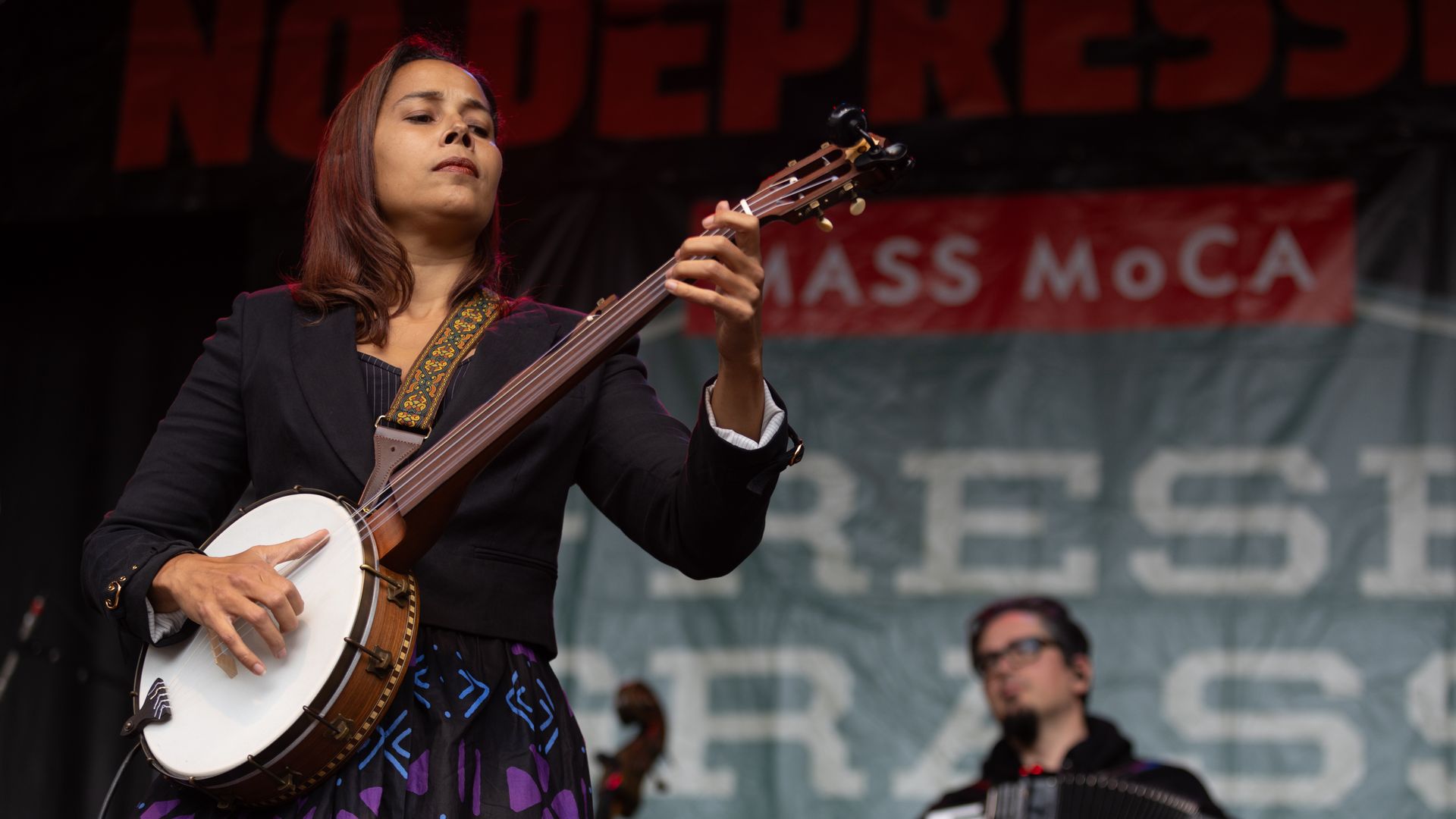Rhiannon Giddens plays a banjo on a stage